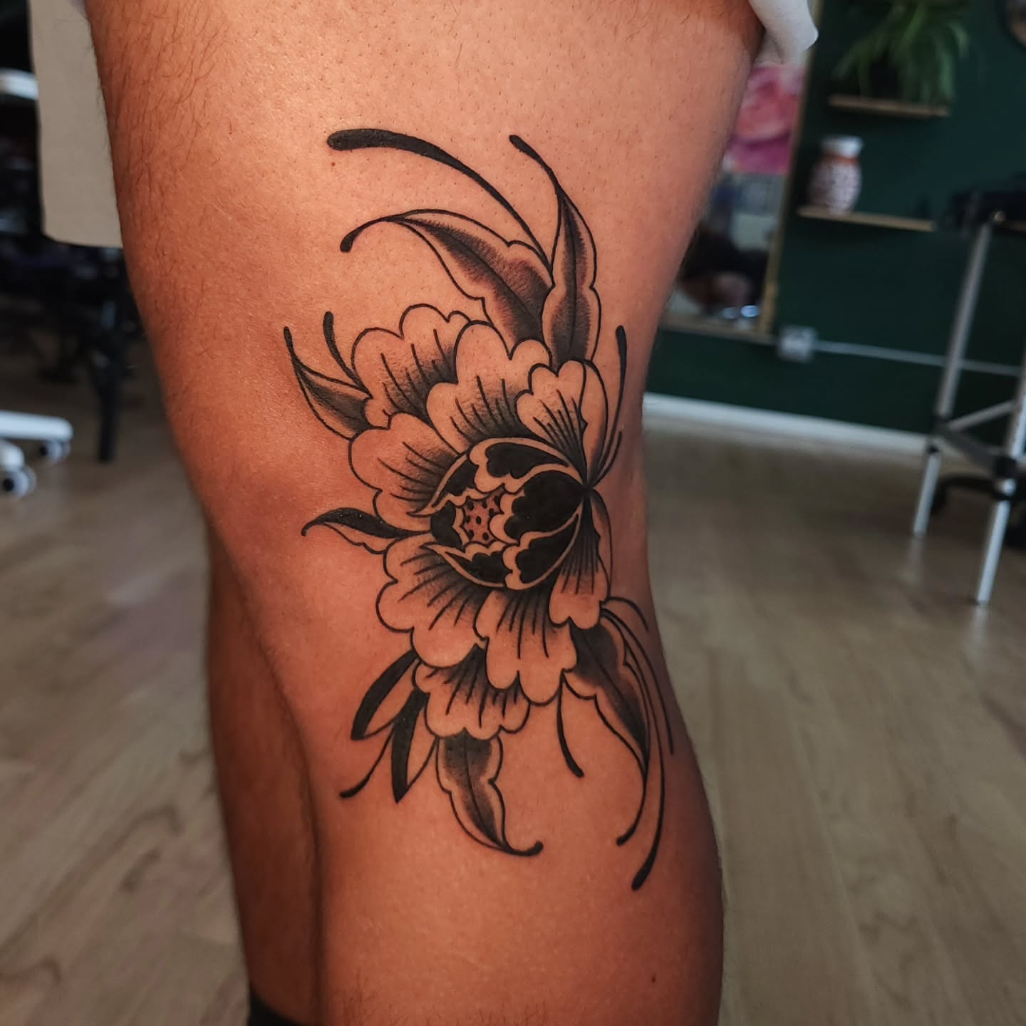 Peony black and grey tattoo on the thigh by Maxine Stewart