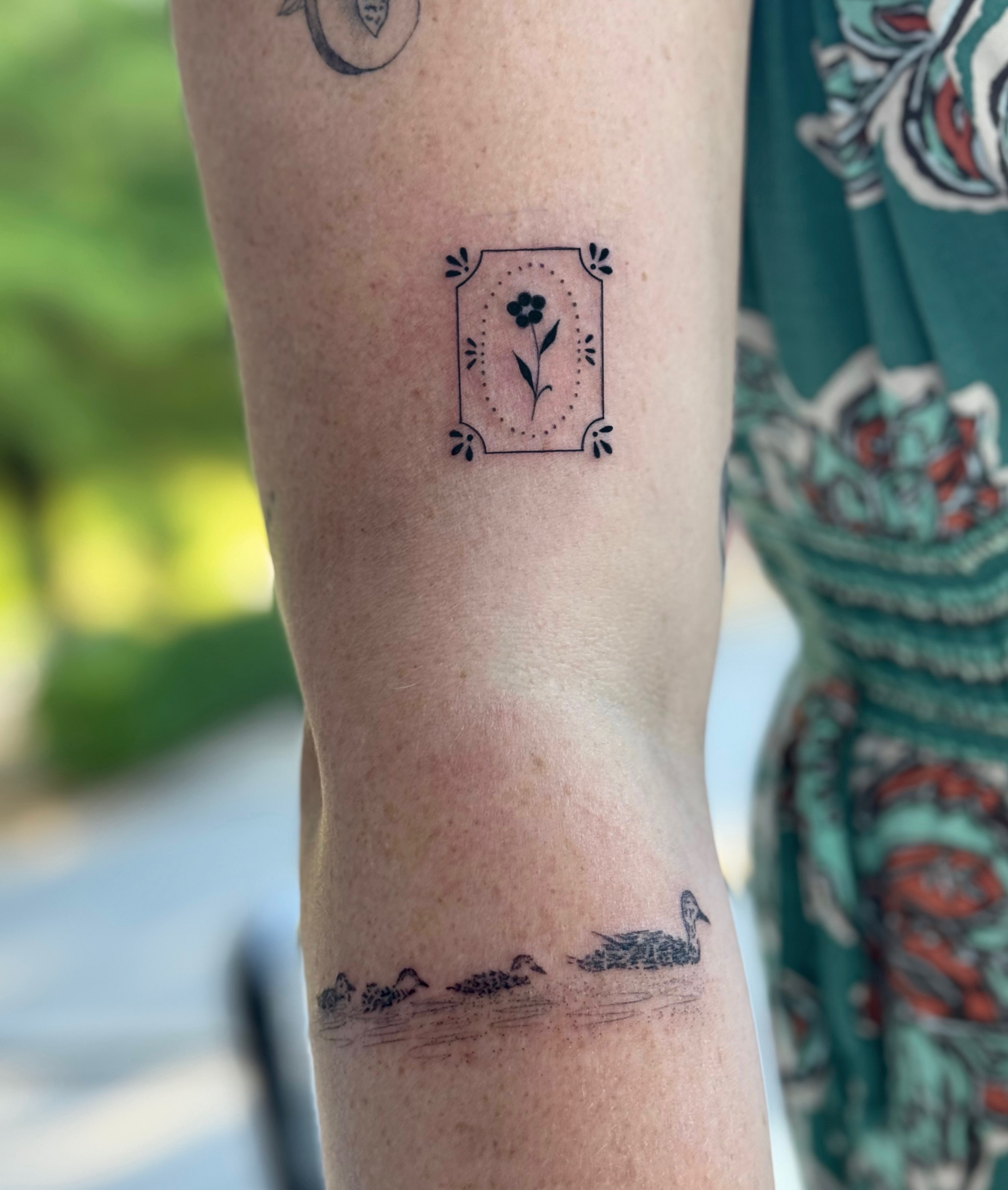 Flower in frame black and grey tattoo on the forearm by Emily Velletta, Huntersville, North Carolina