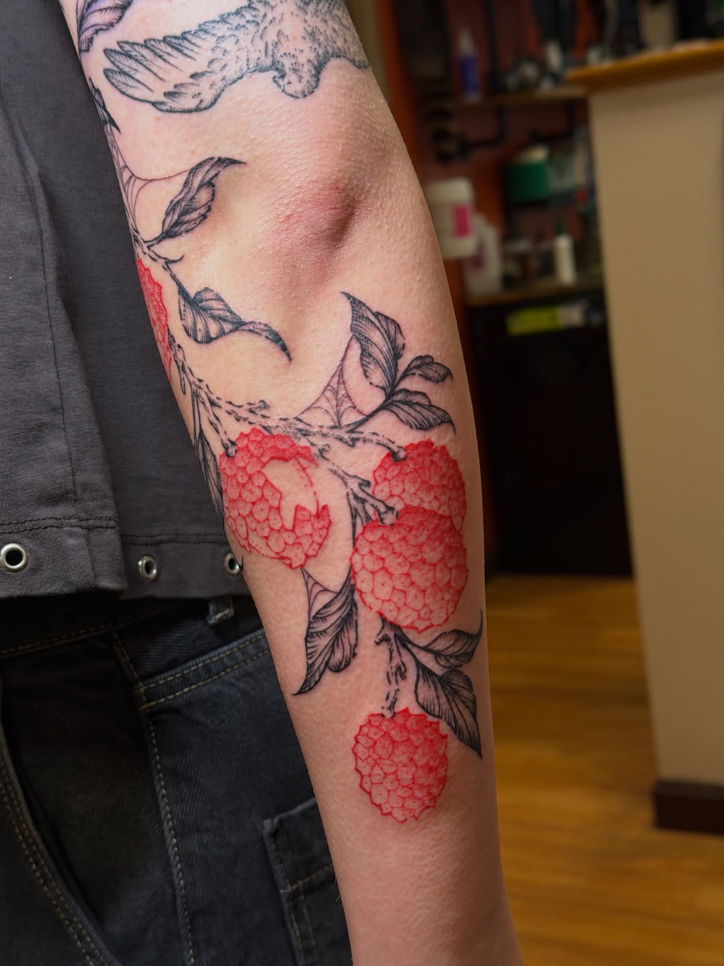 Raspberries and leaves black and grey tattoo on the forearm by Gianna Calisi