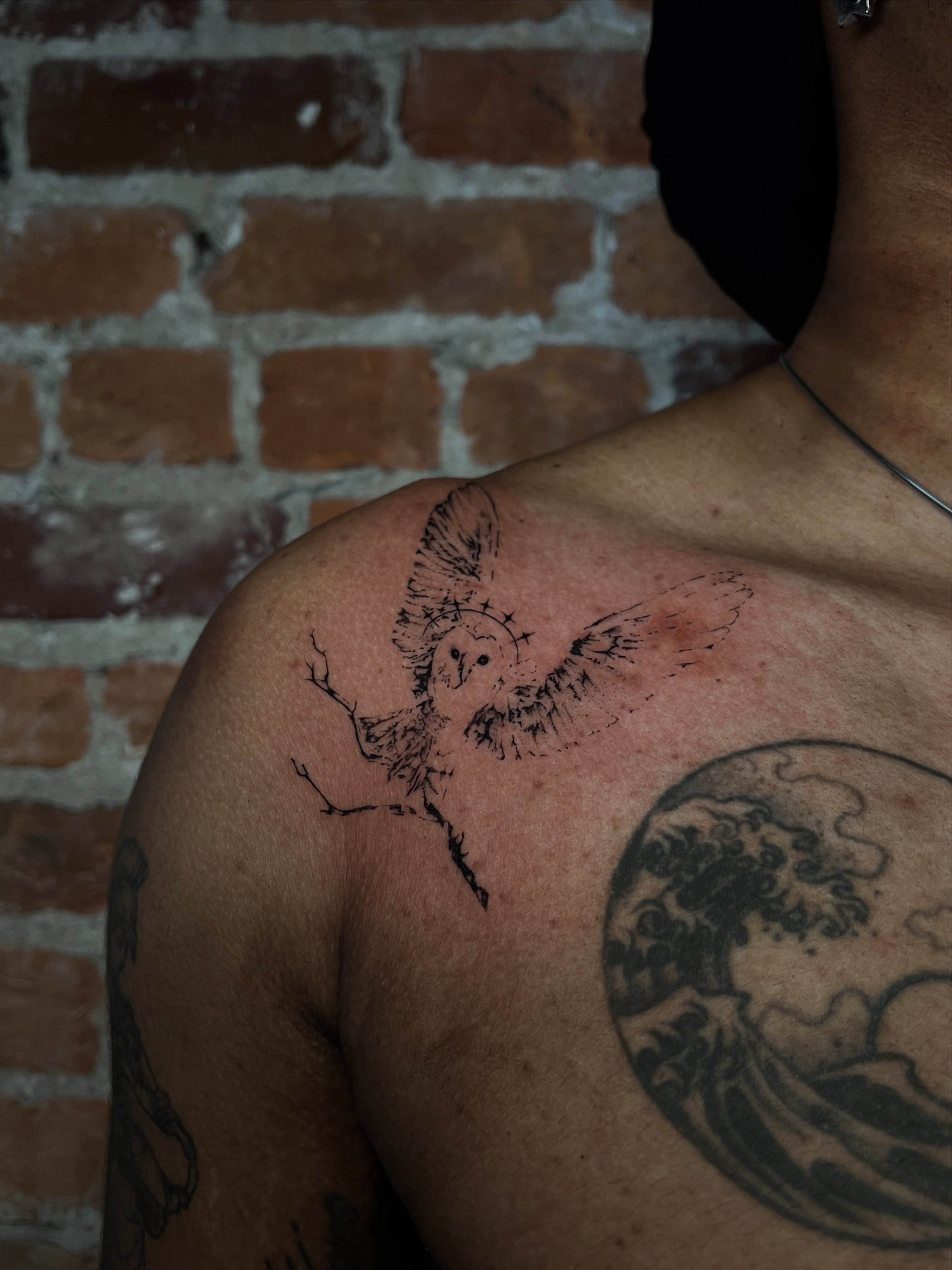 Owl black and grey tattoo on the shoulder by Uncomfy Comfort Tattoos LLC