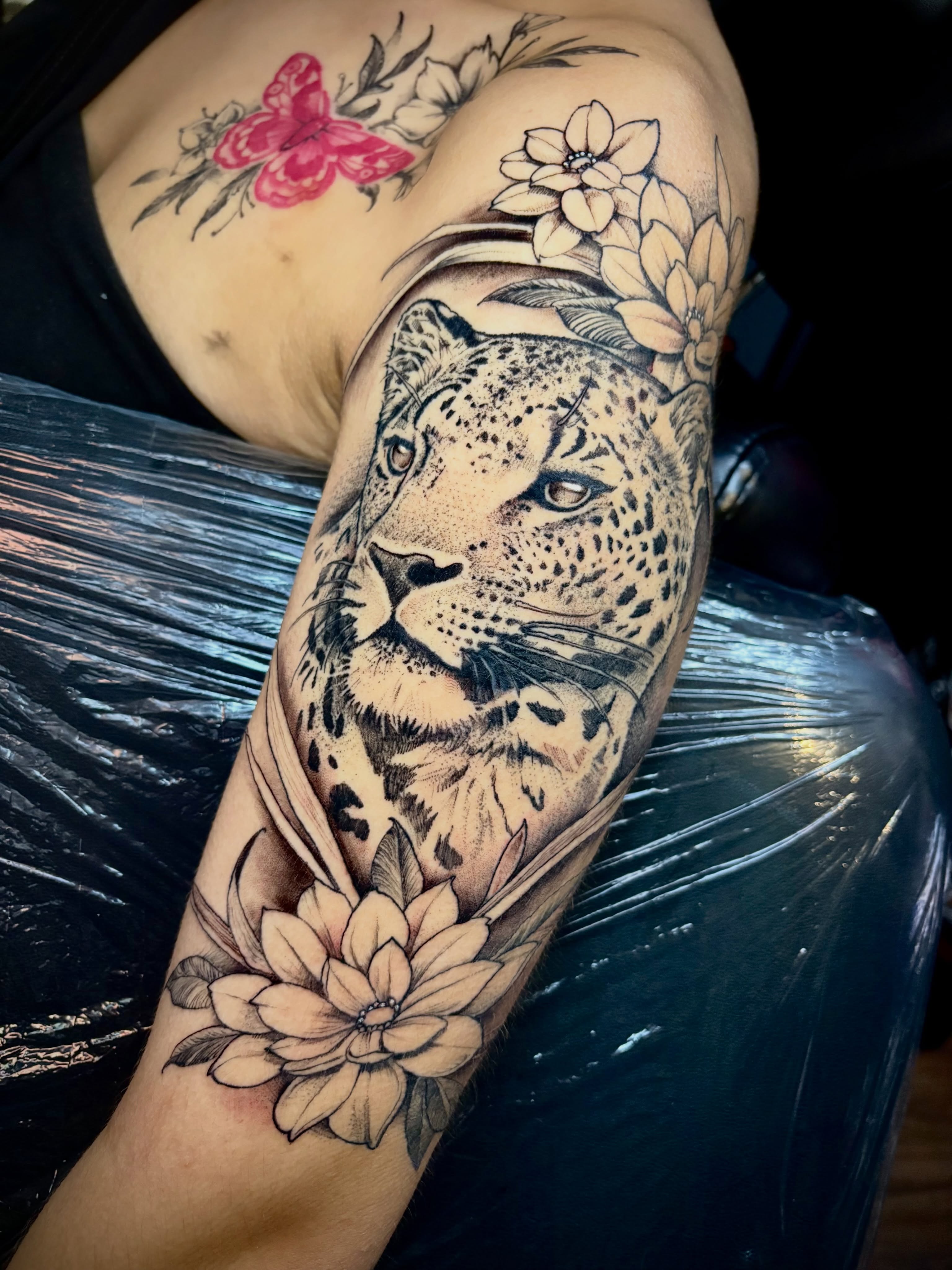 Snow leopard realism tattoo on the forearm by Adam Newton