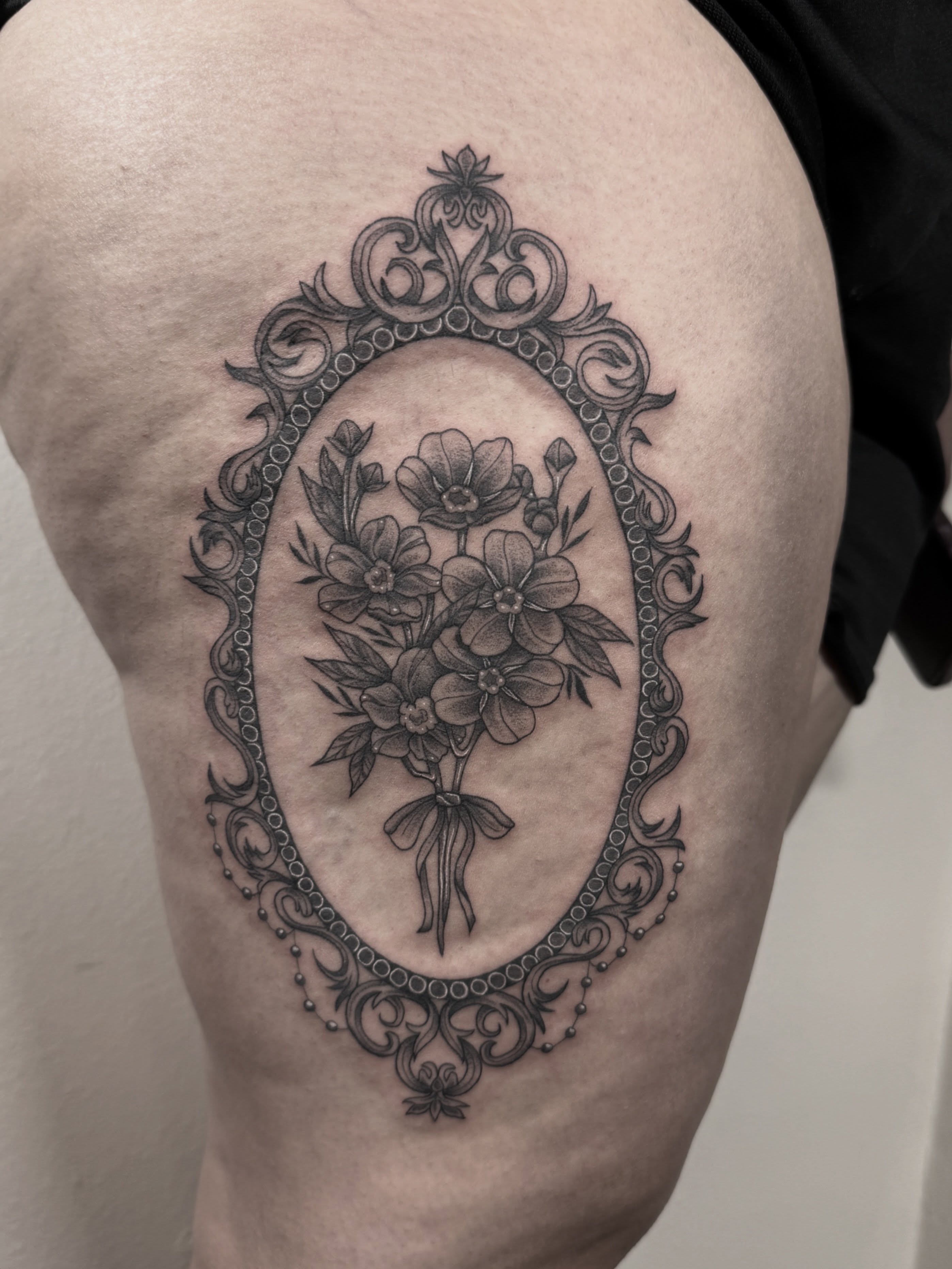 Flower bouquet black and grey tattoo on the thigh by Mara Flores βπΛβ§