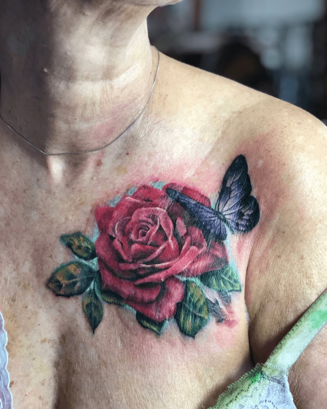 Rose and butterfly neo-traditional tattoo on the chest by Gabriel Torres