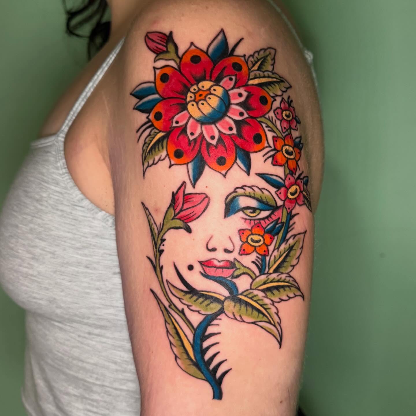 Floral portrait American traditional tattoo on the upper arm by charlie