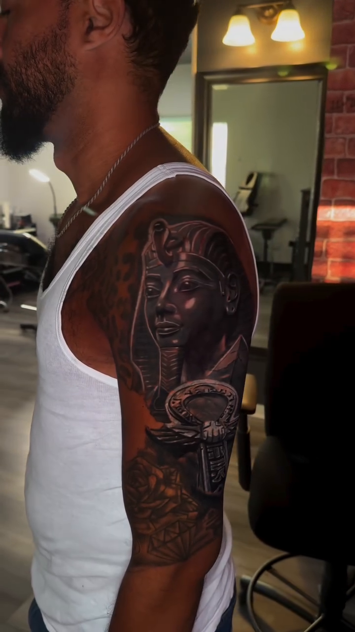 Egyptian pharaoh bust with sarcophagus realism tattoo on the upper arm by Miguel Garcia