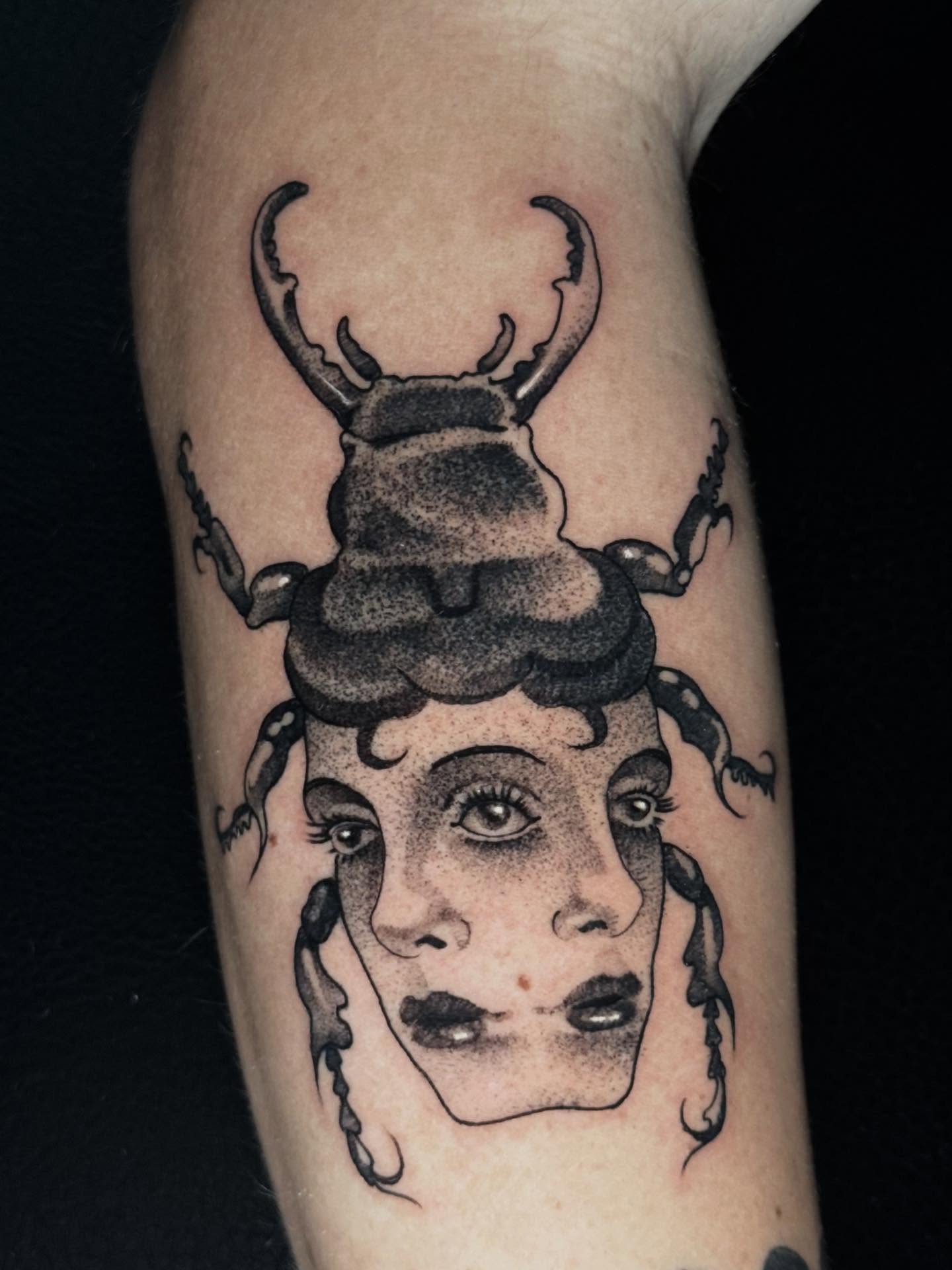 Woman with beetle dotwork tattoo on the forearm by Mads Ink