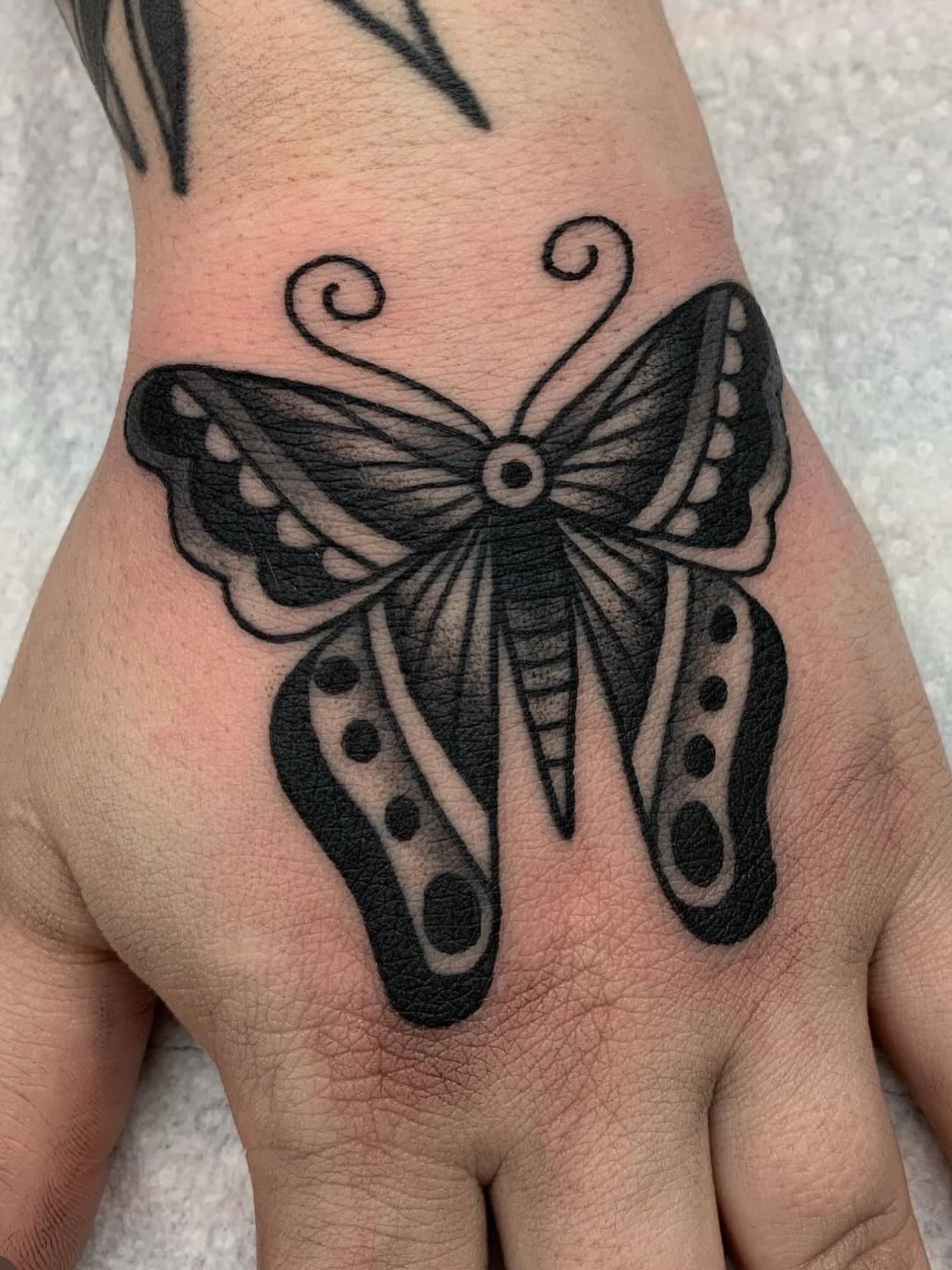 Butterfly black and grey tattoo on the hand by Kelsey Lane