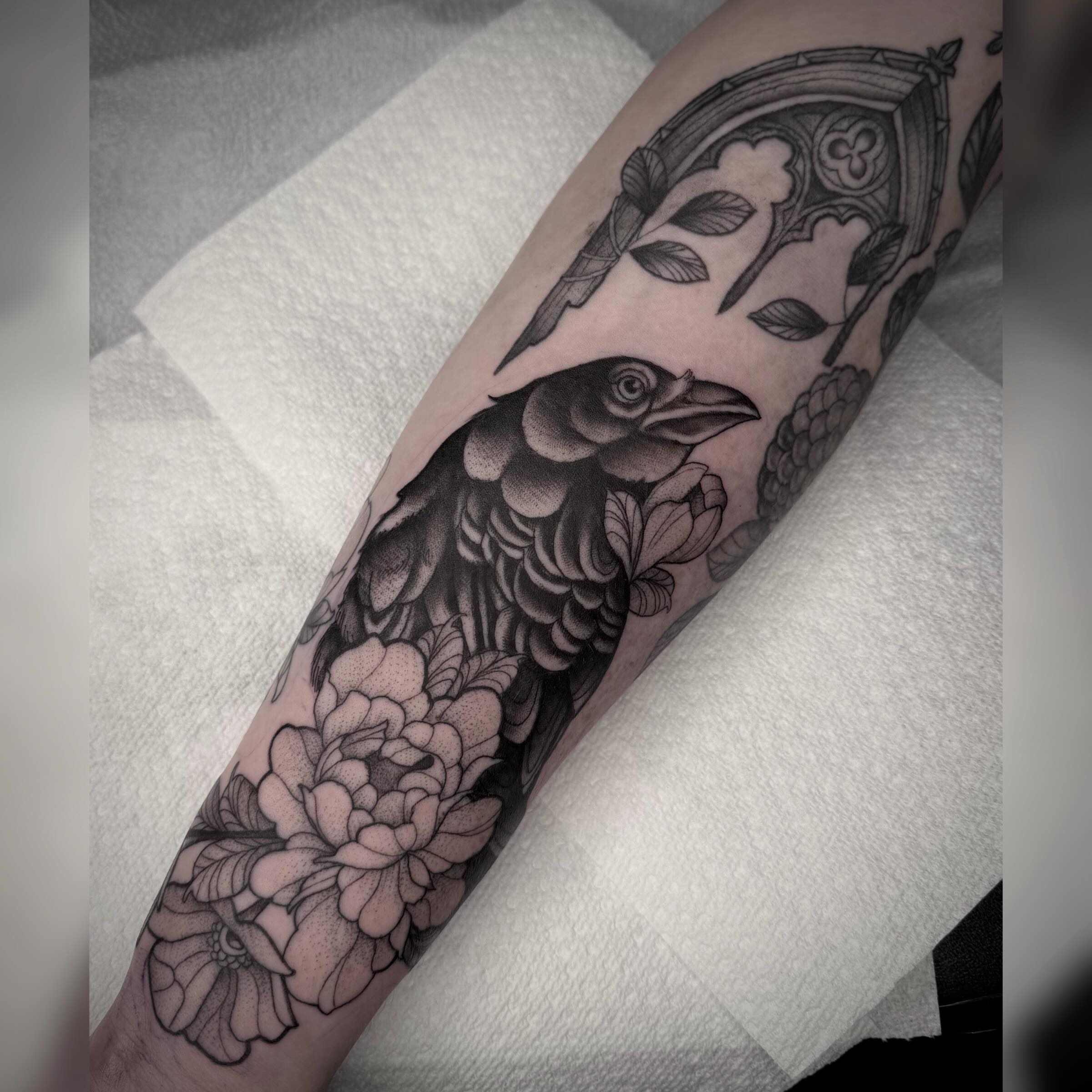 Crow and floral dotwork tattoo on the forearm by Alyssa Deeghan
