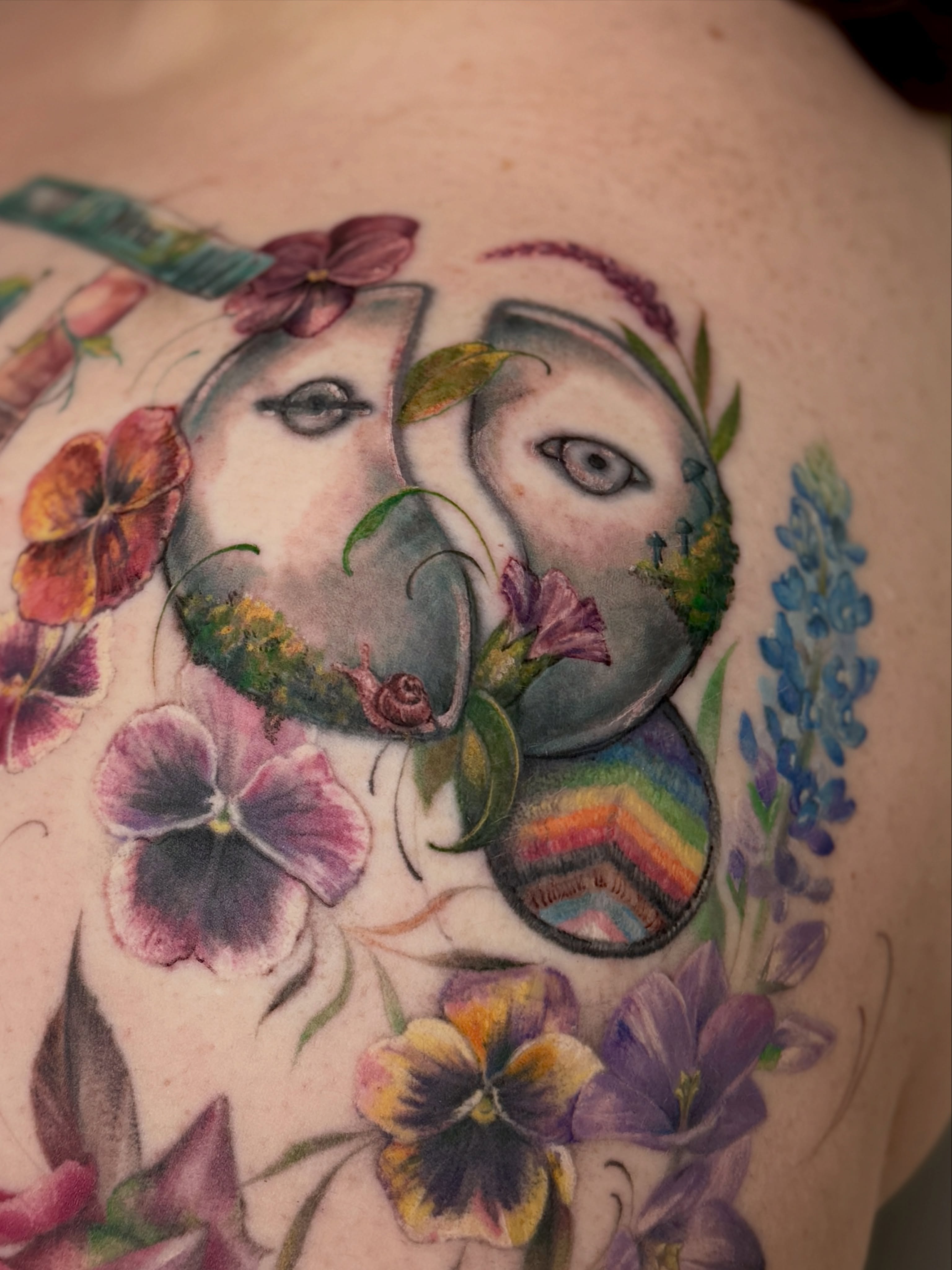 Abstract faces with flowers watercolor tattoo on the shoulder by Andy Rowe- Tattoo Artist🦇