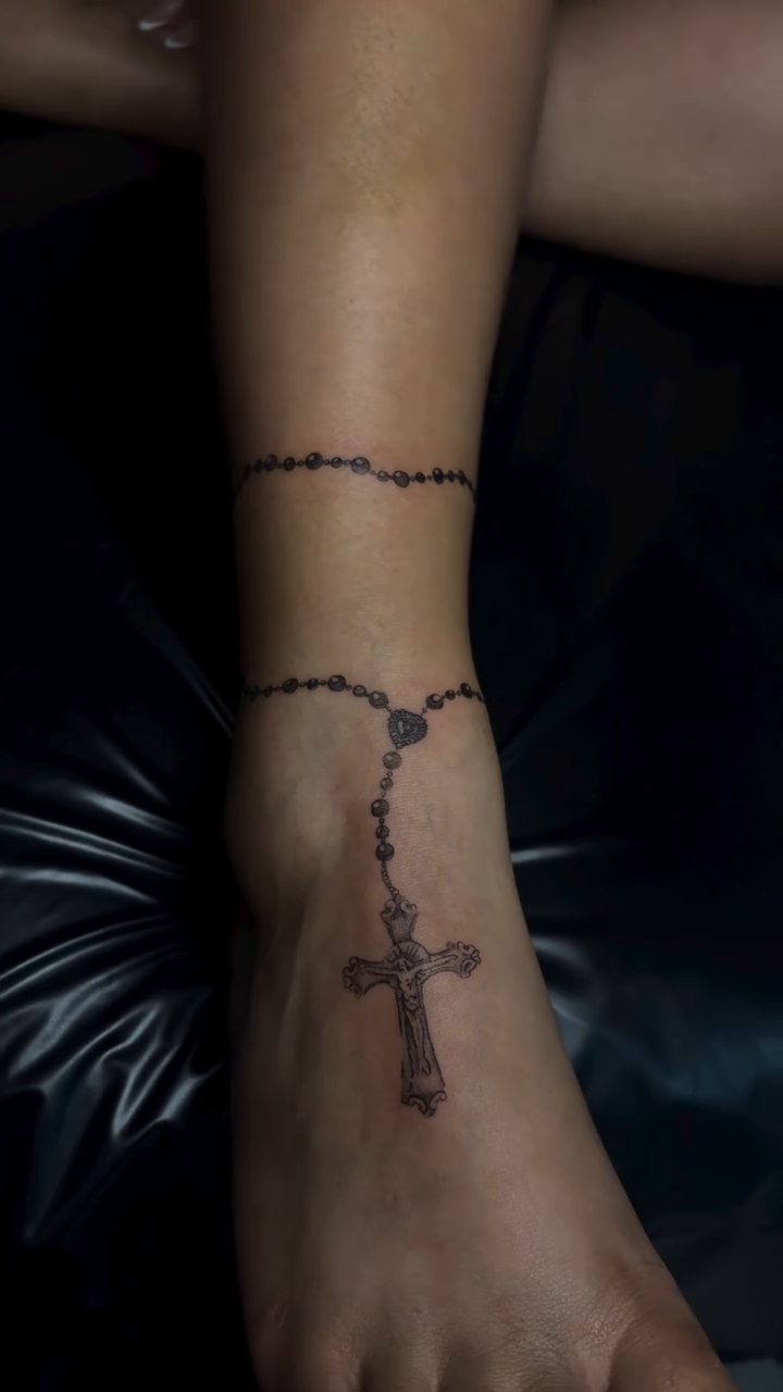 Rosary ankle bracelet with cross ornamental tattoo on the foot by Valentina