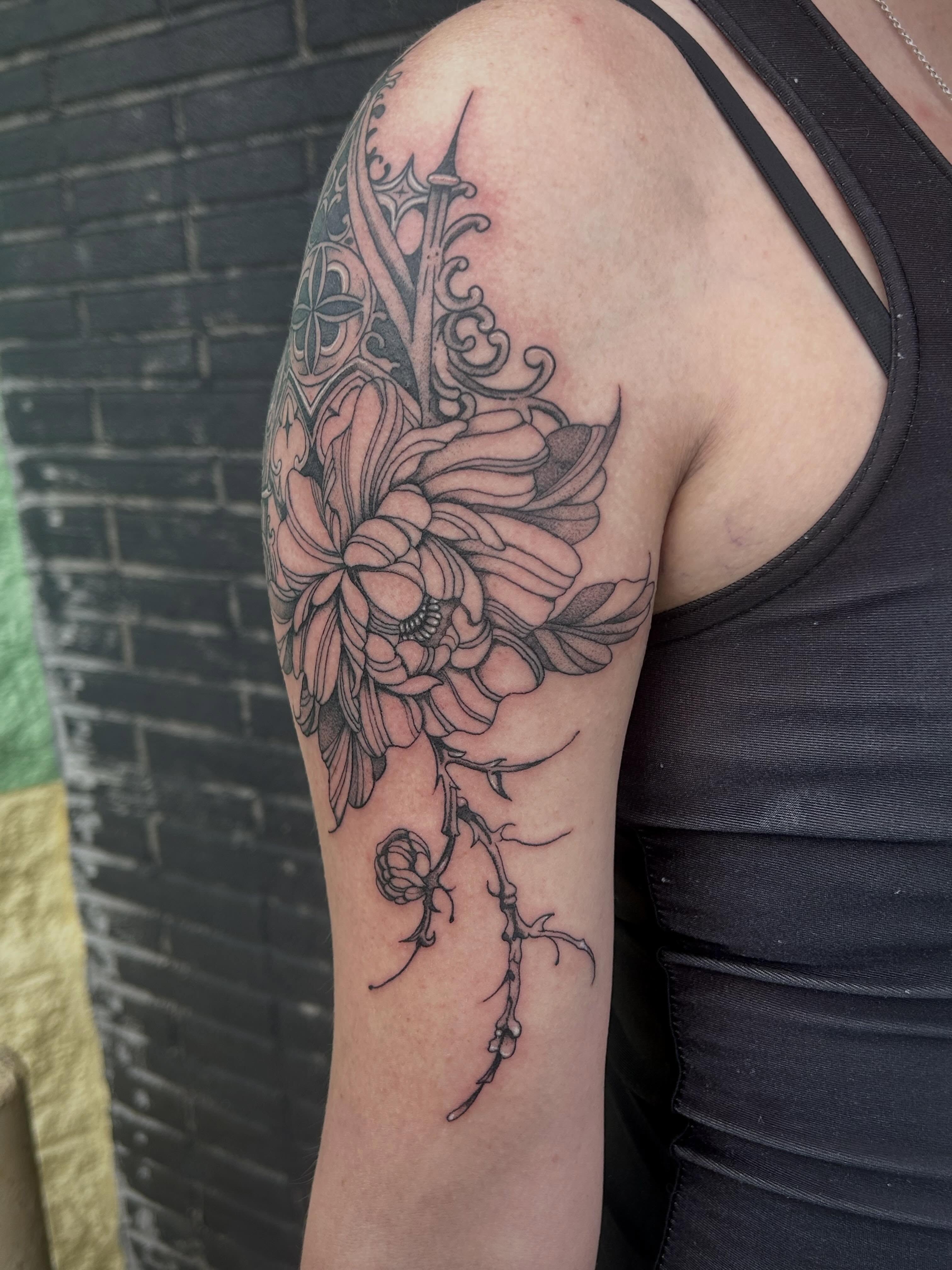 Chrysanthemum black and grey tattoo on the upper arm by Bria🩸
