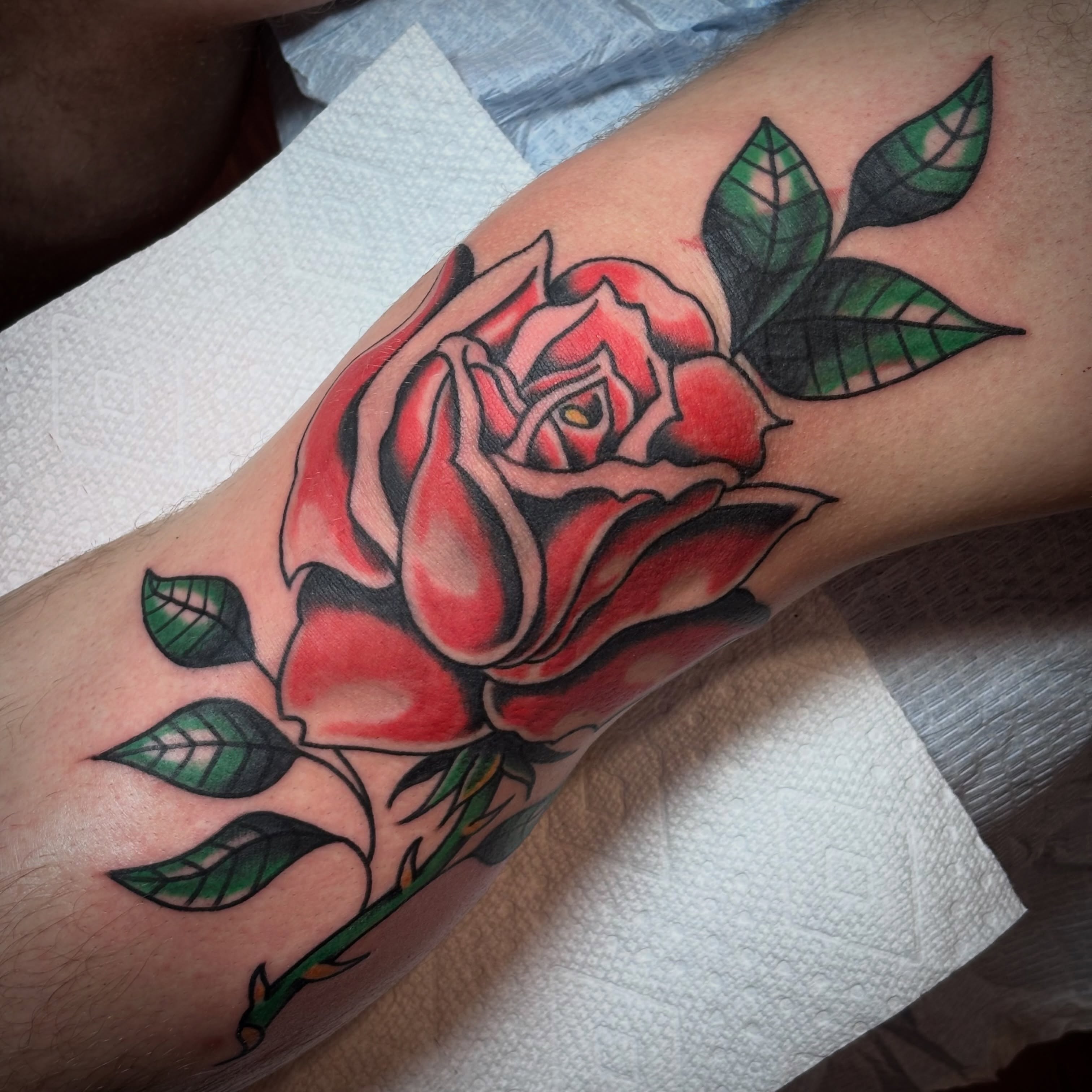 Red rose American traditional tattoo on the forearm by Malachi