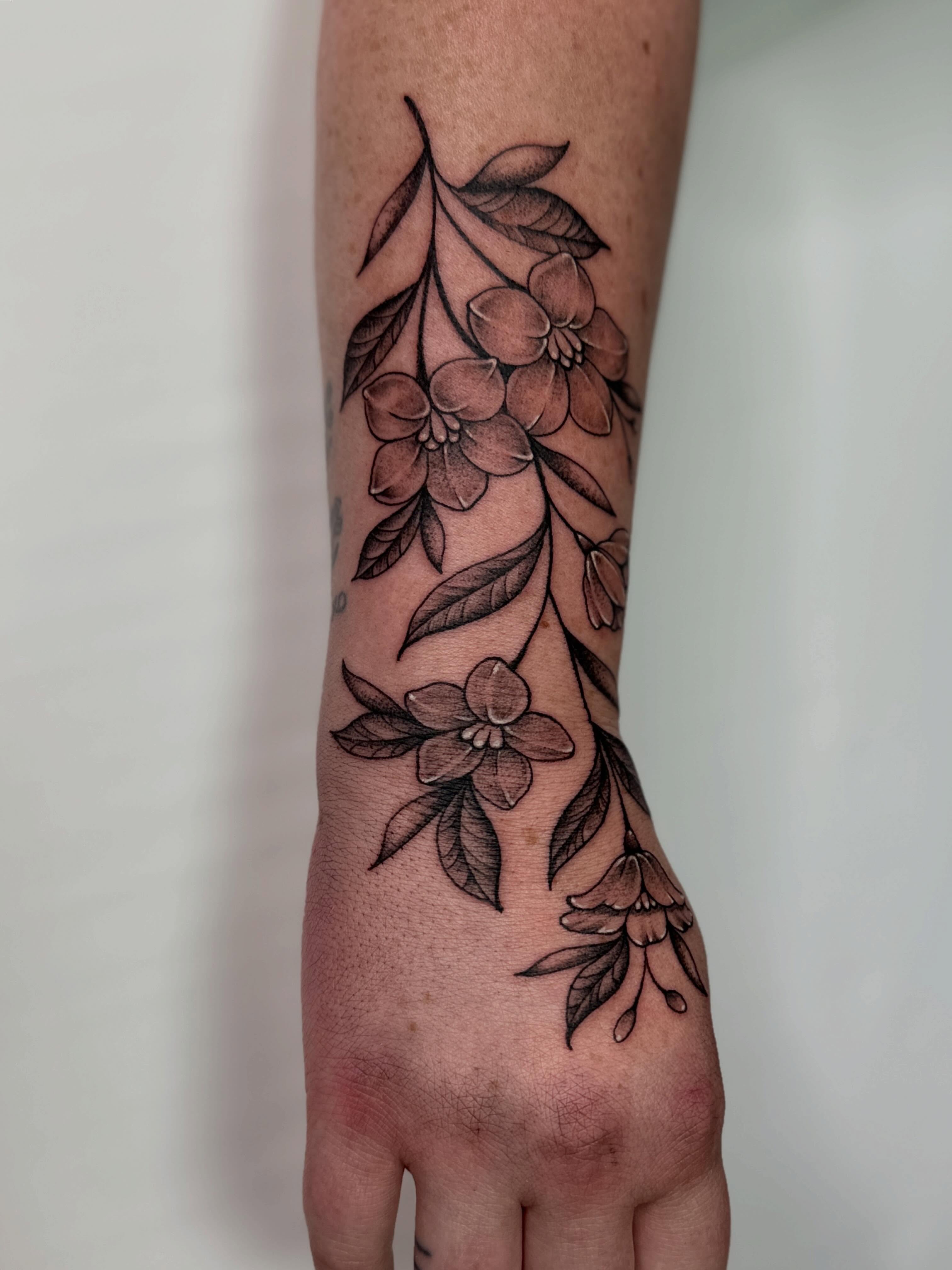 Flower branch black and grey tattoo on the forearm by Dani Di Pietrantonio