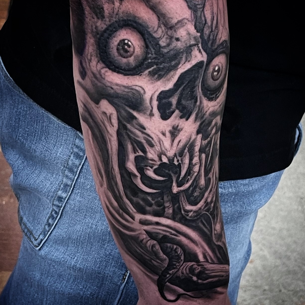 Demon face dark realism tattoo on the forearm by Jason Oz, Denver, Colorado