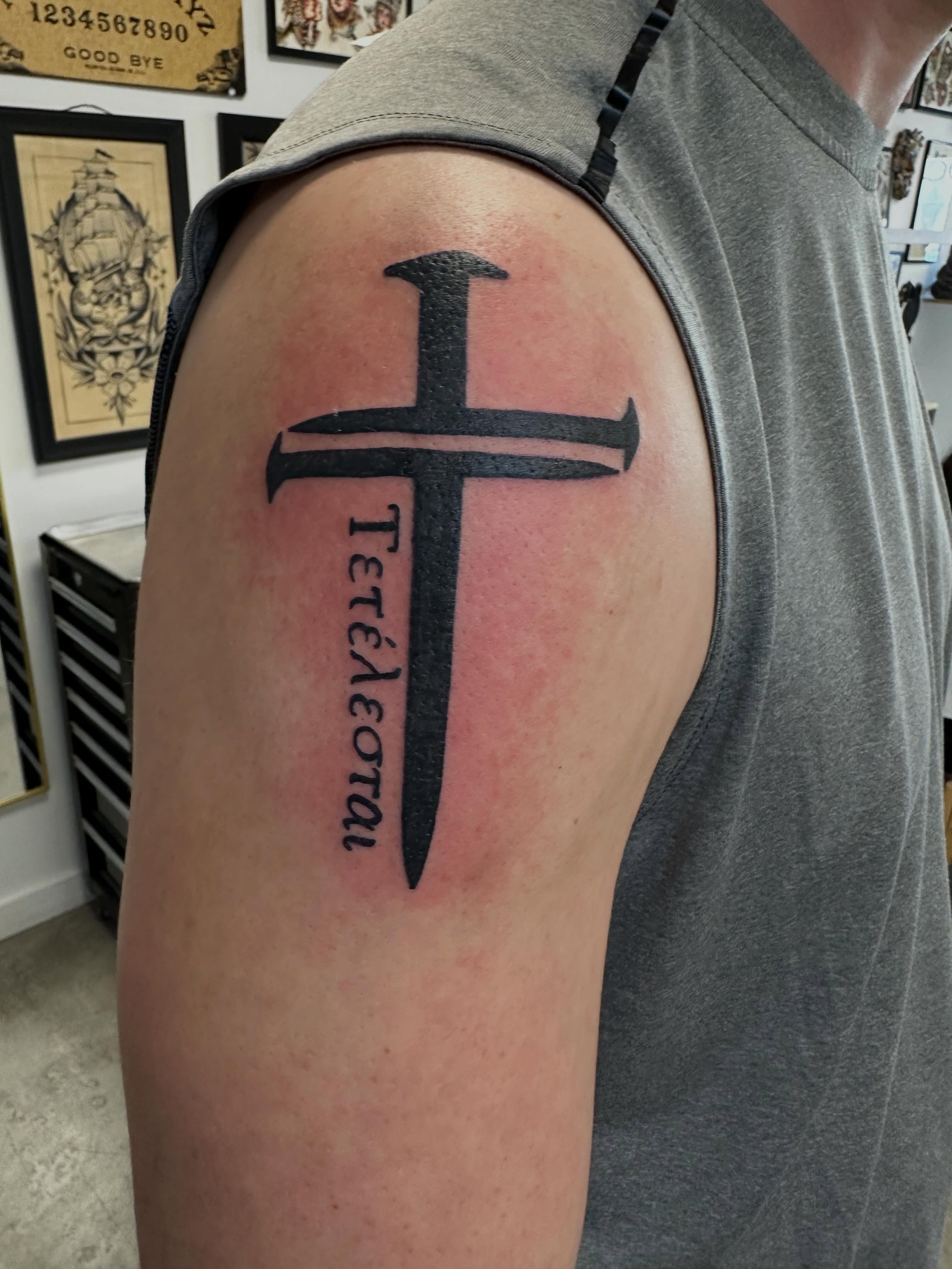 Cross with lettering black and grey tattoo on the shoulder by Vincent Merys