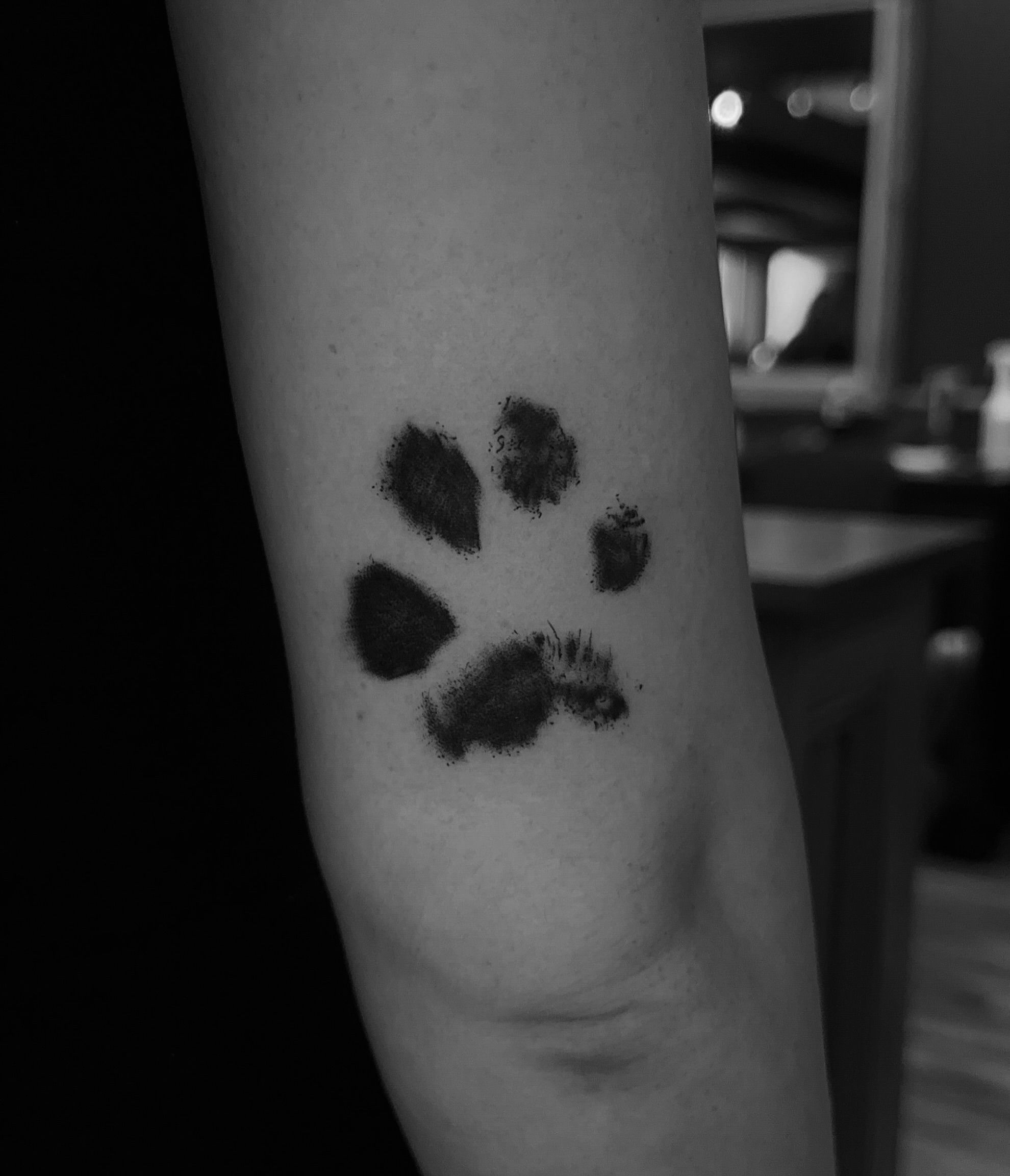 Paw print black and grey tattoo on the forearm by Leo Fernandes, Danvers, Massachusetts