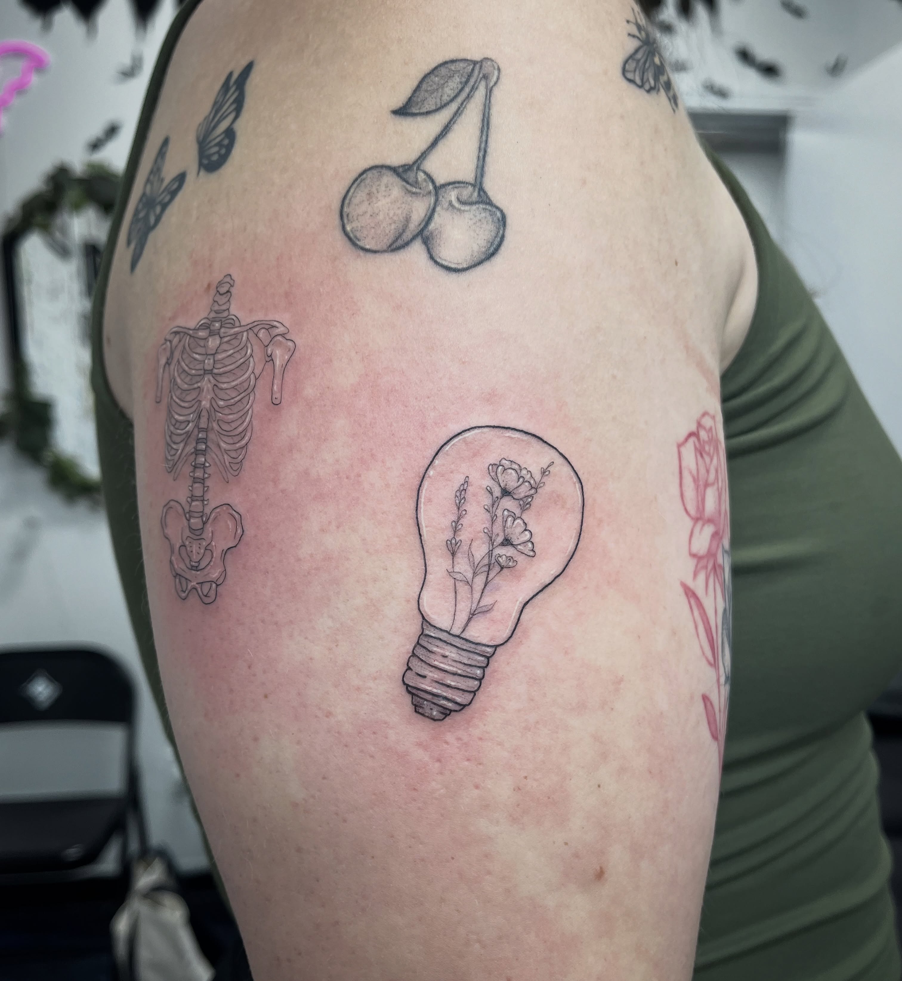 Cherry and light bulb black and grey tattoo on the shoulder by Sid