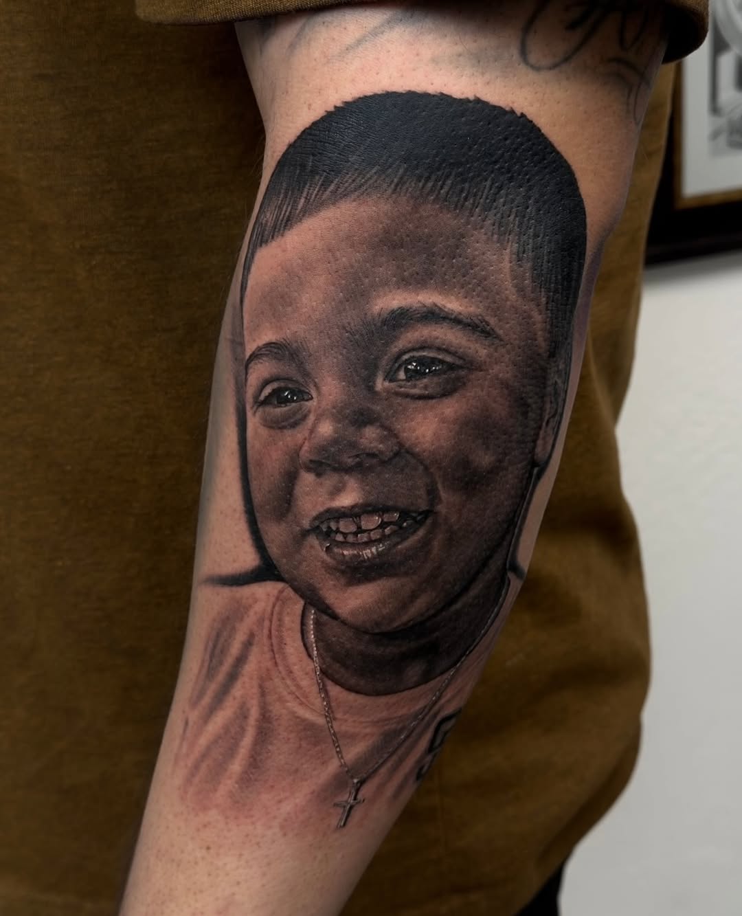 Portrait of a child realism tattoo on the forearm by Richie Moreno lll