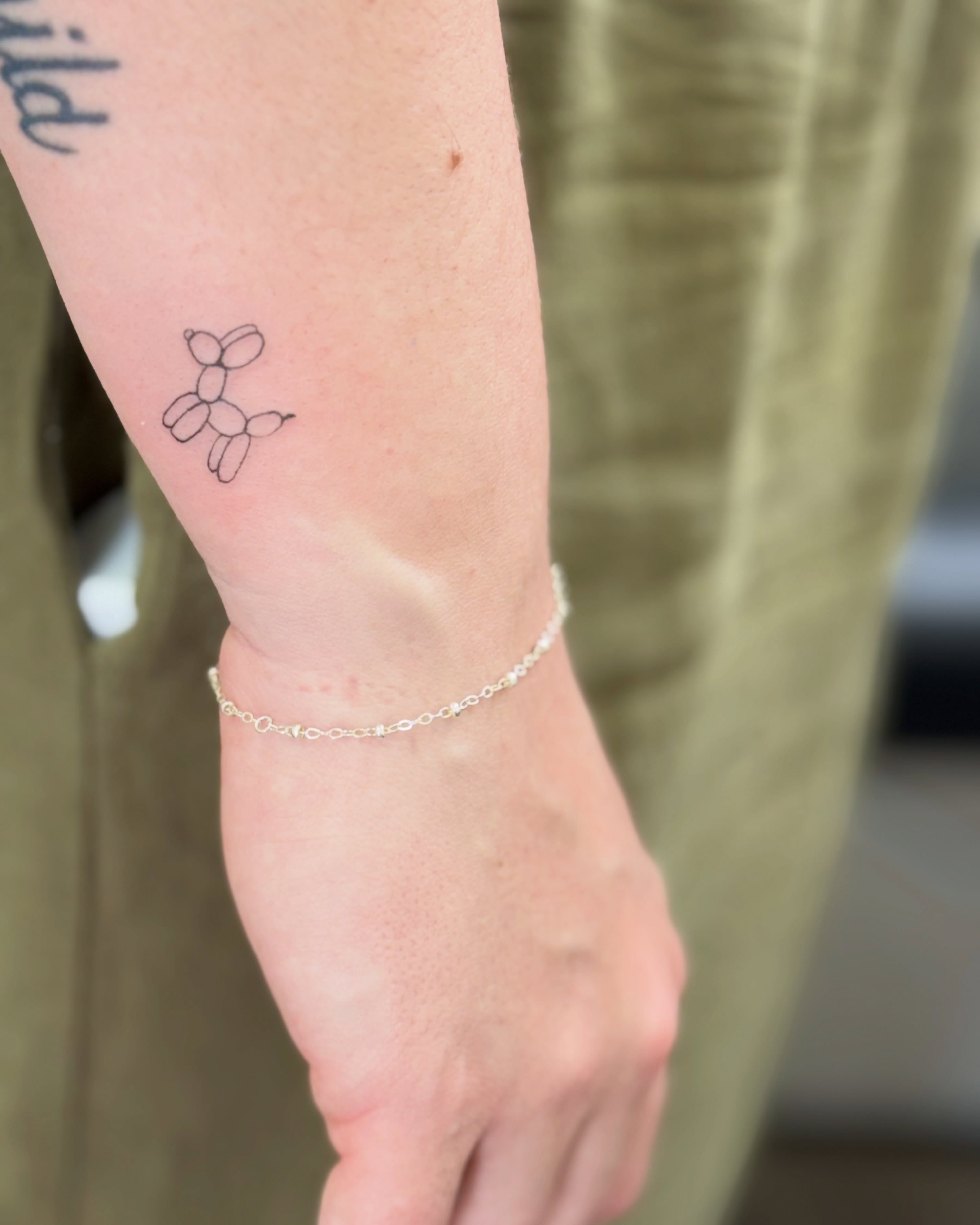 Balloon dog minimalist tattoo on the forearm by Fineline Tattoo