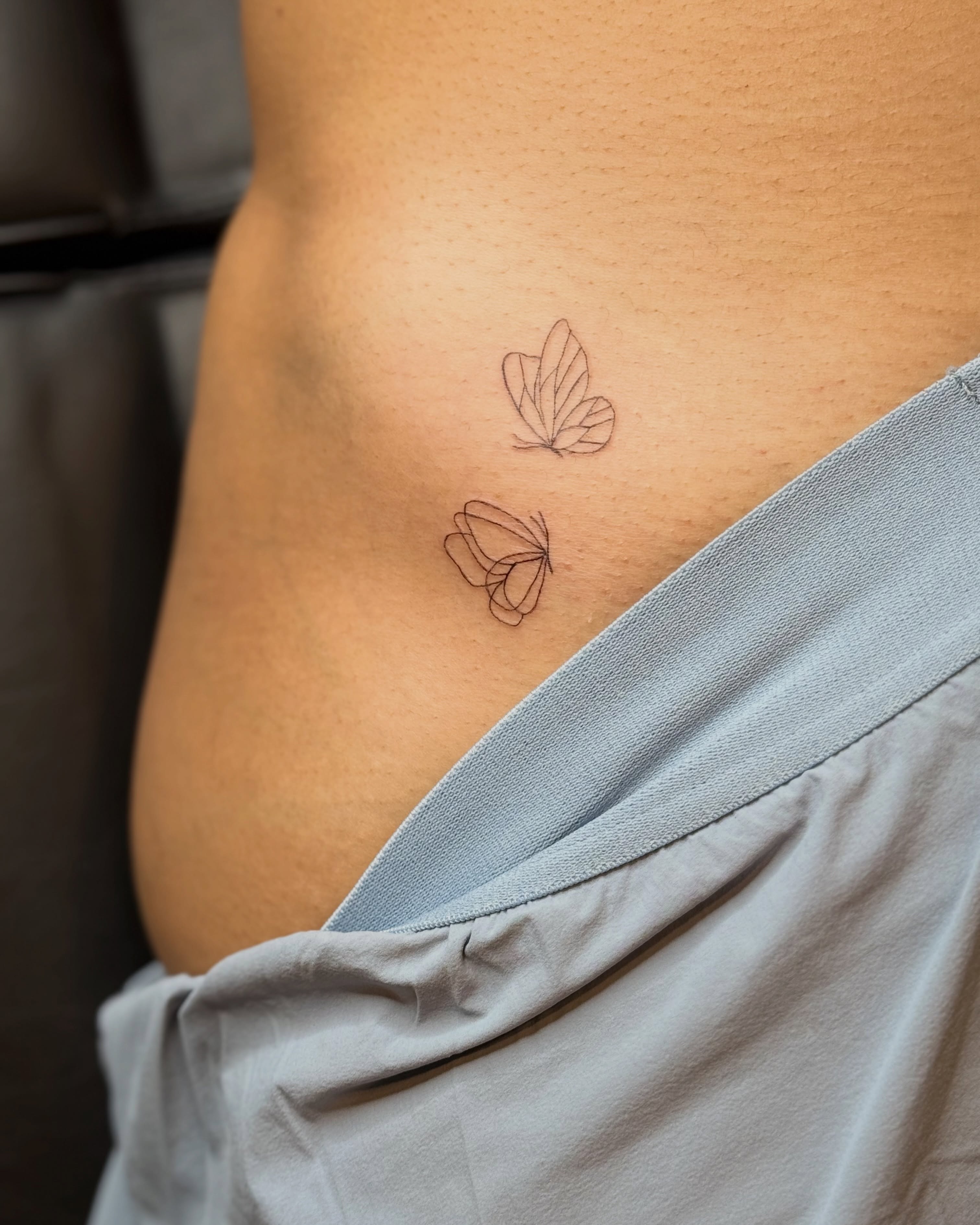 Butterfly fine line tattoo on the ribs by Fineline Tattoo