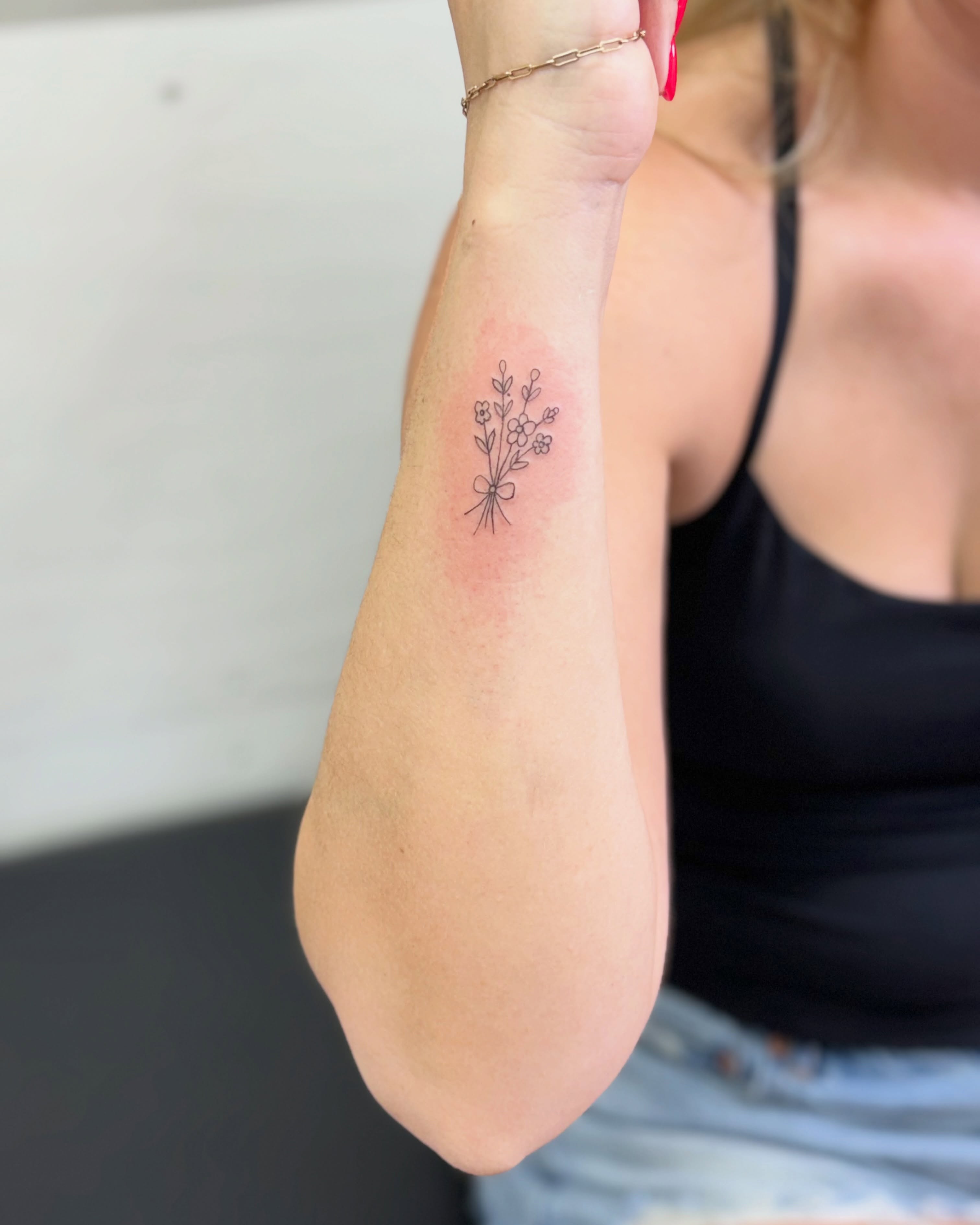Flower bouquet fine line tattoo on the forearm by Fineline Tattoo