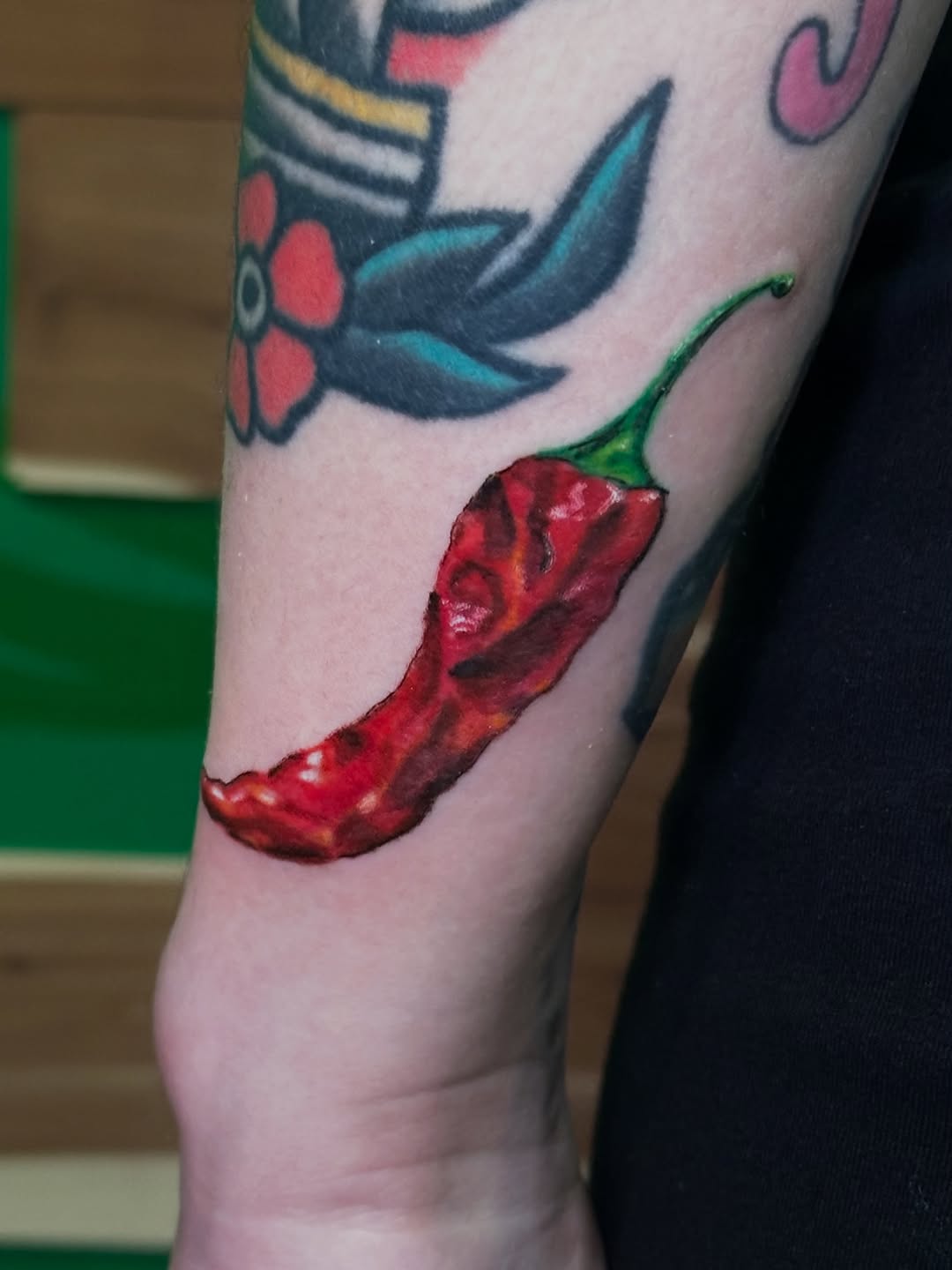 Red chili pepper American traditional tattoo on the forearm by Alexander Haber
