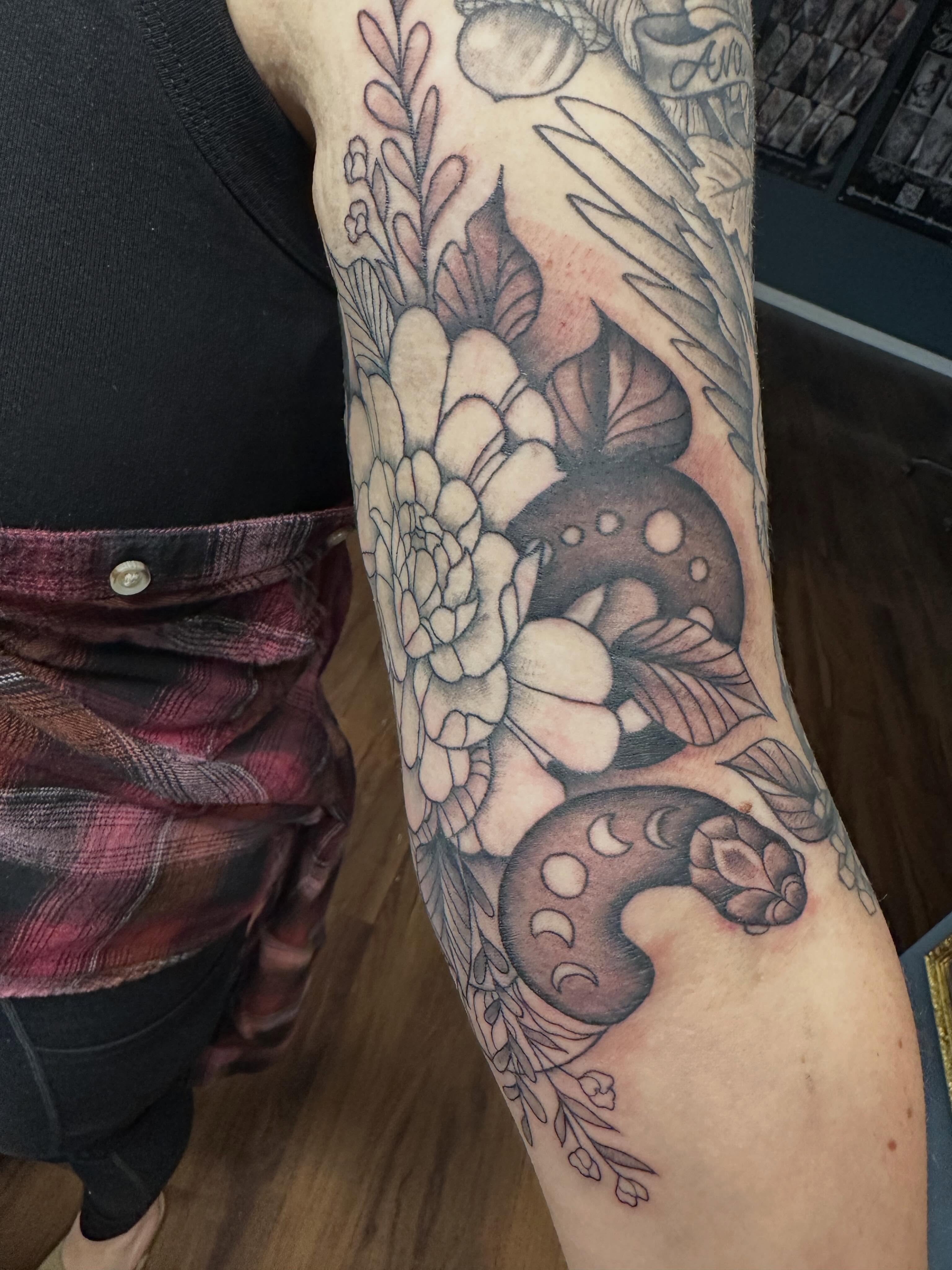 Flower and mushroom black and grey tattoo on the forearm by Lindsey Bendsey