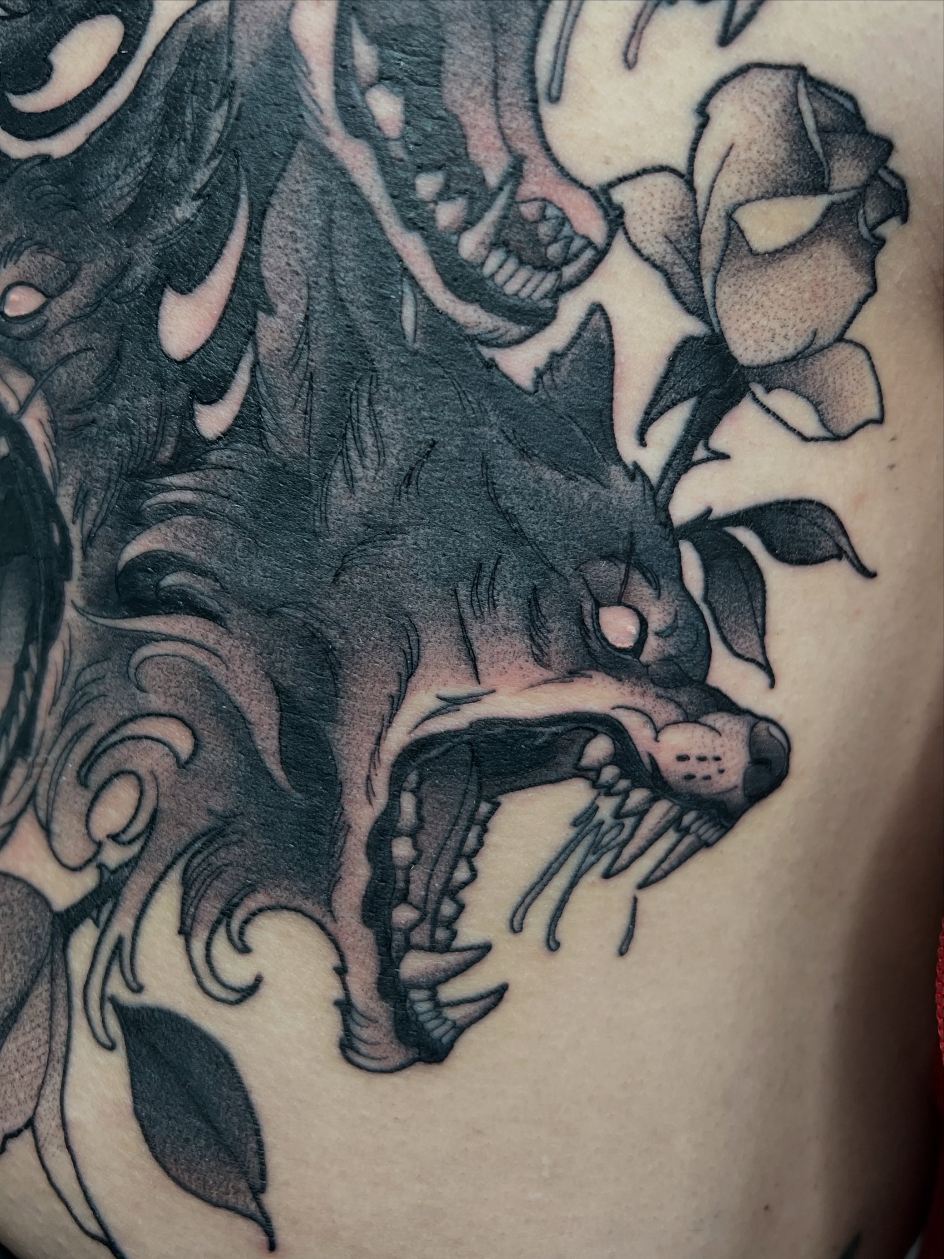 Wolf and roses dark realism tattoo on the shoulder by Nathan Garcia