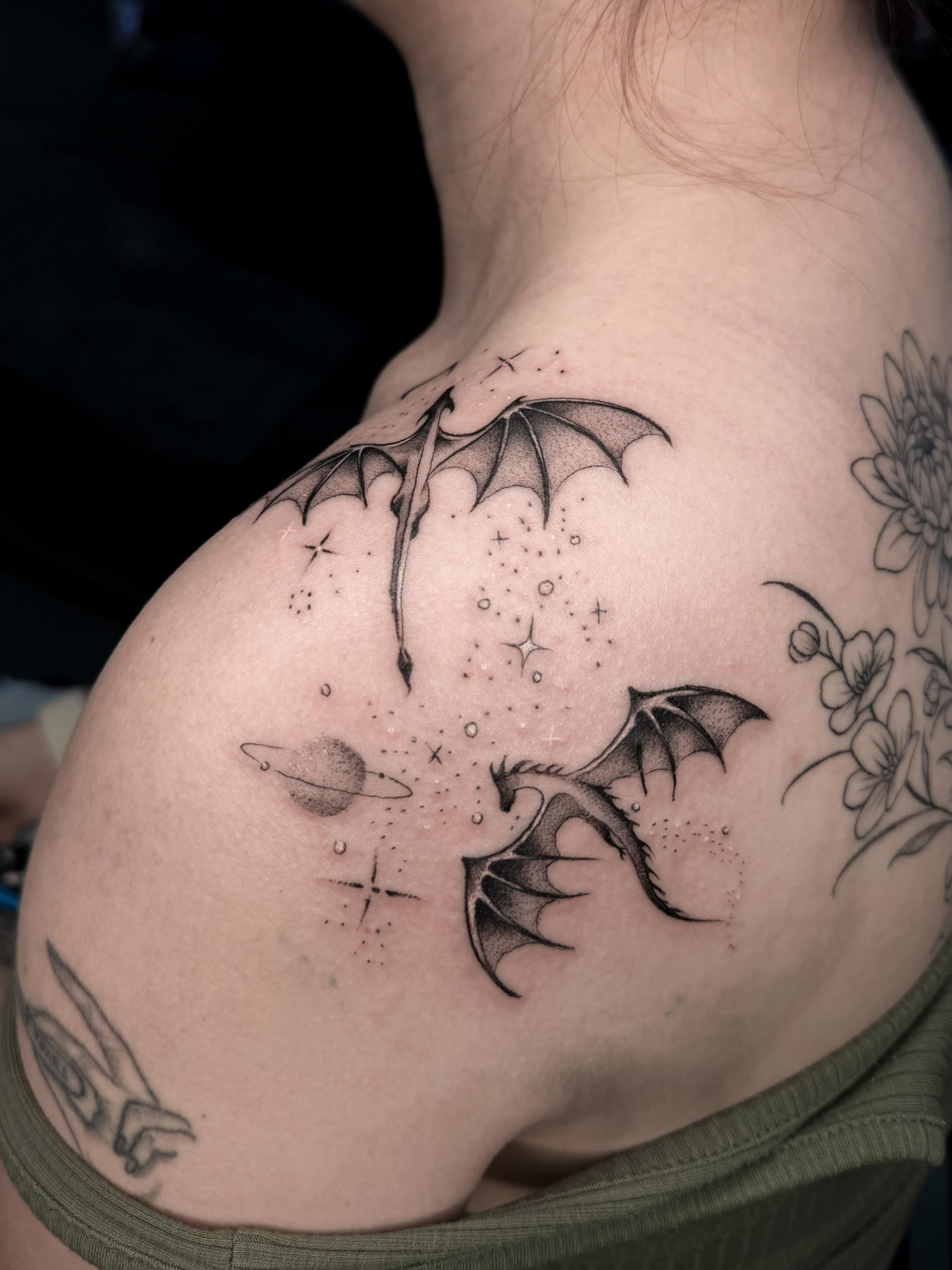 Dragons and stars dotwork tattoo on the shoulder by Susie Maj