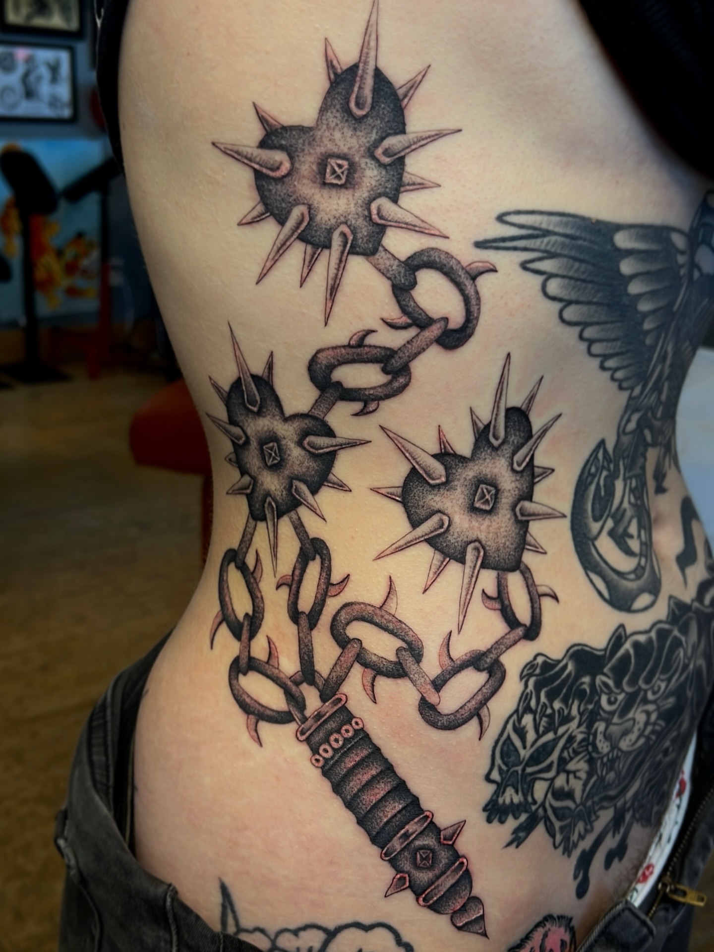 Spiked weapon and chains American traditional tattoo on the ribs by David Delacruz