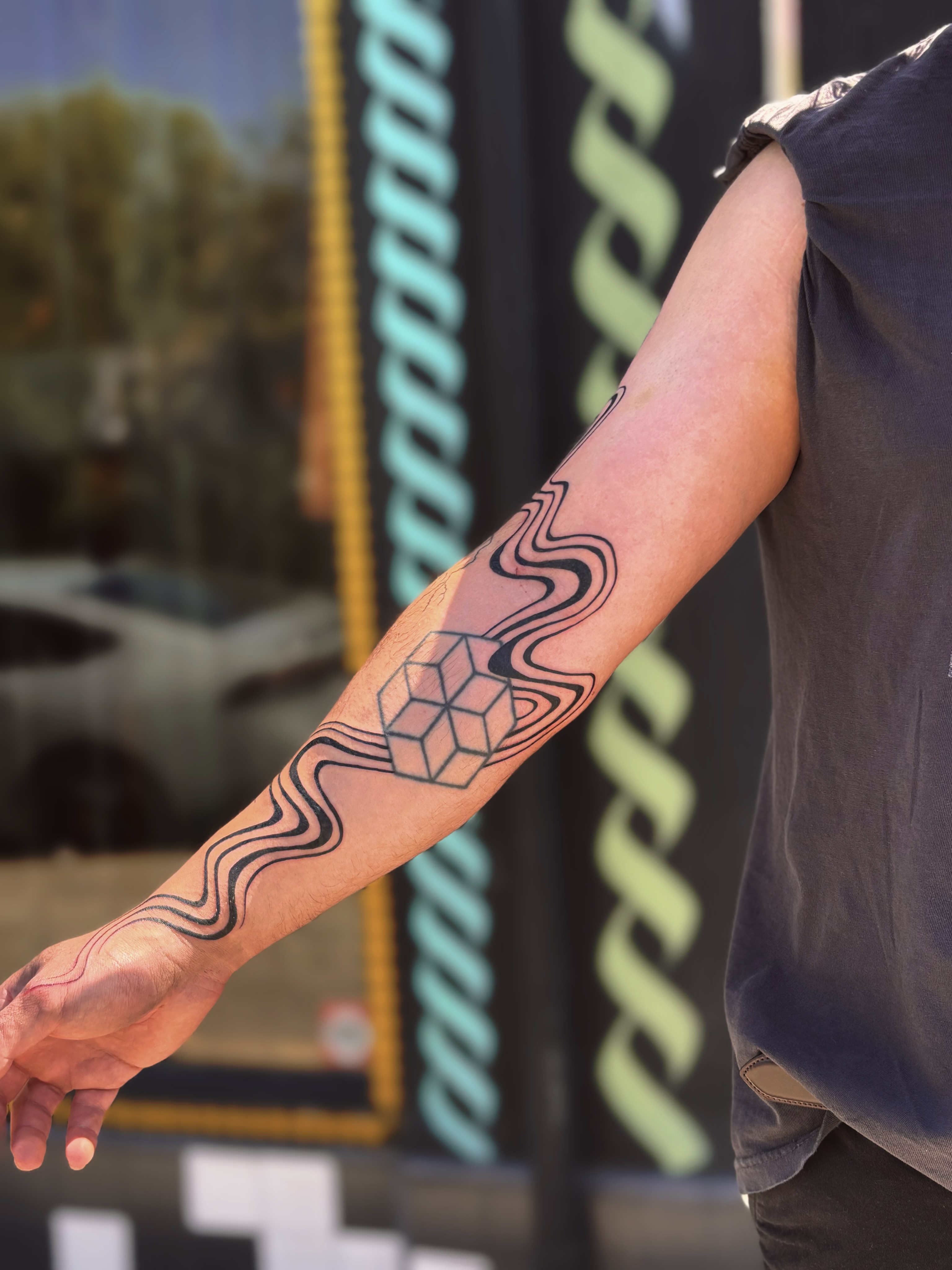 Wave pattern geometric tattoo on the forearm by Storm Smith