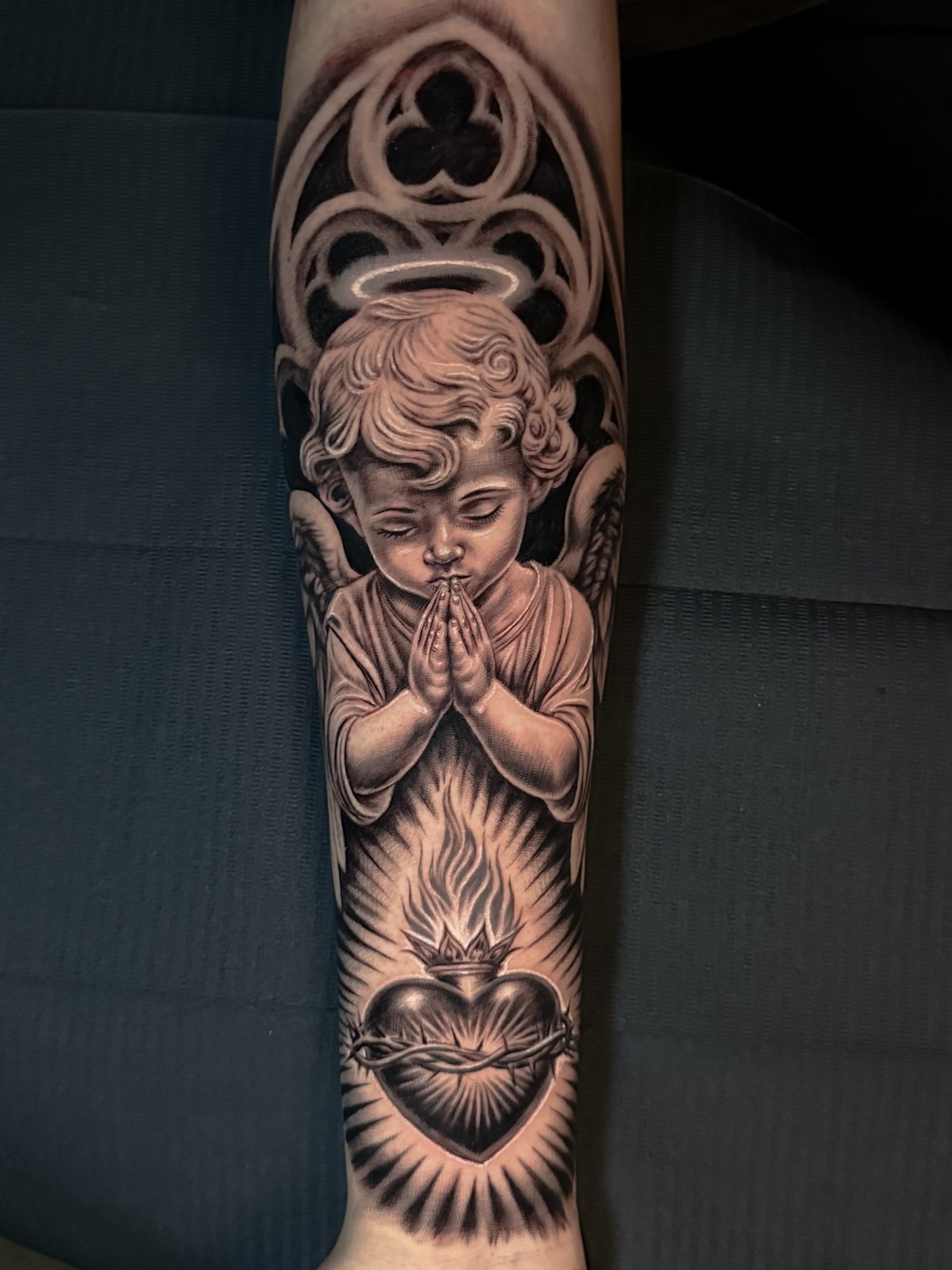 Praying child with heart realism tattoo on the forearm by Omar Sheriff Herrera