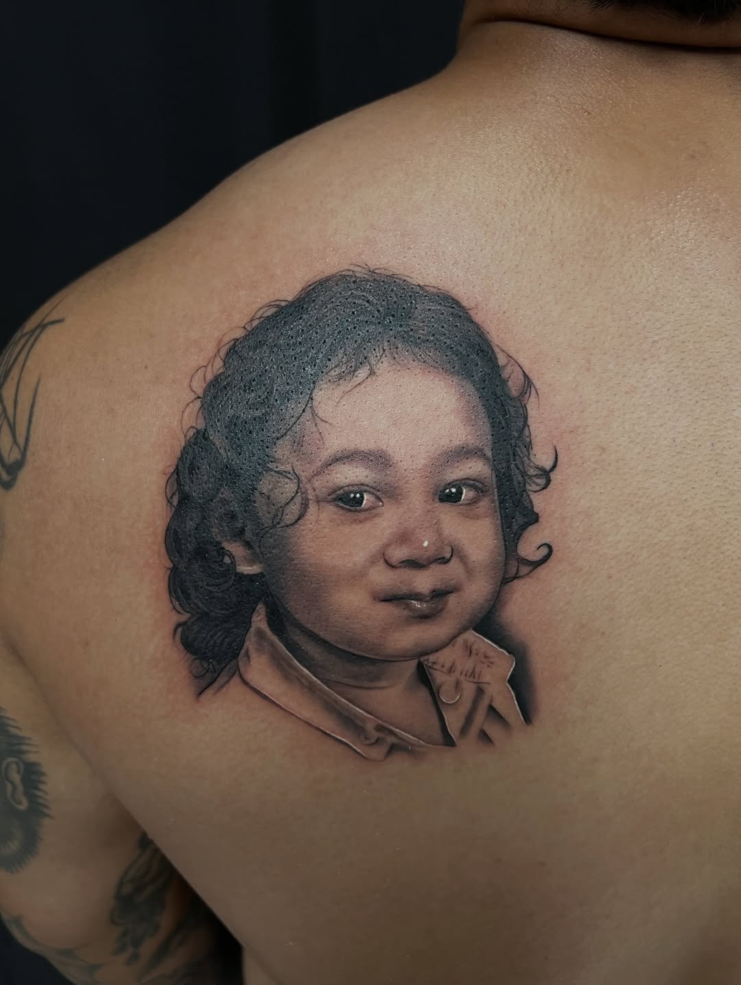 Child portrait Chicano tattoo on the shoulder by Thomas Conard