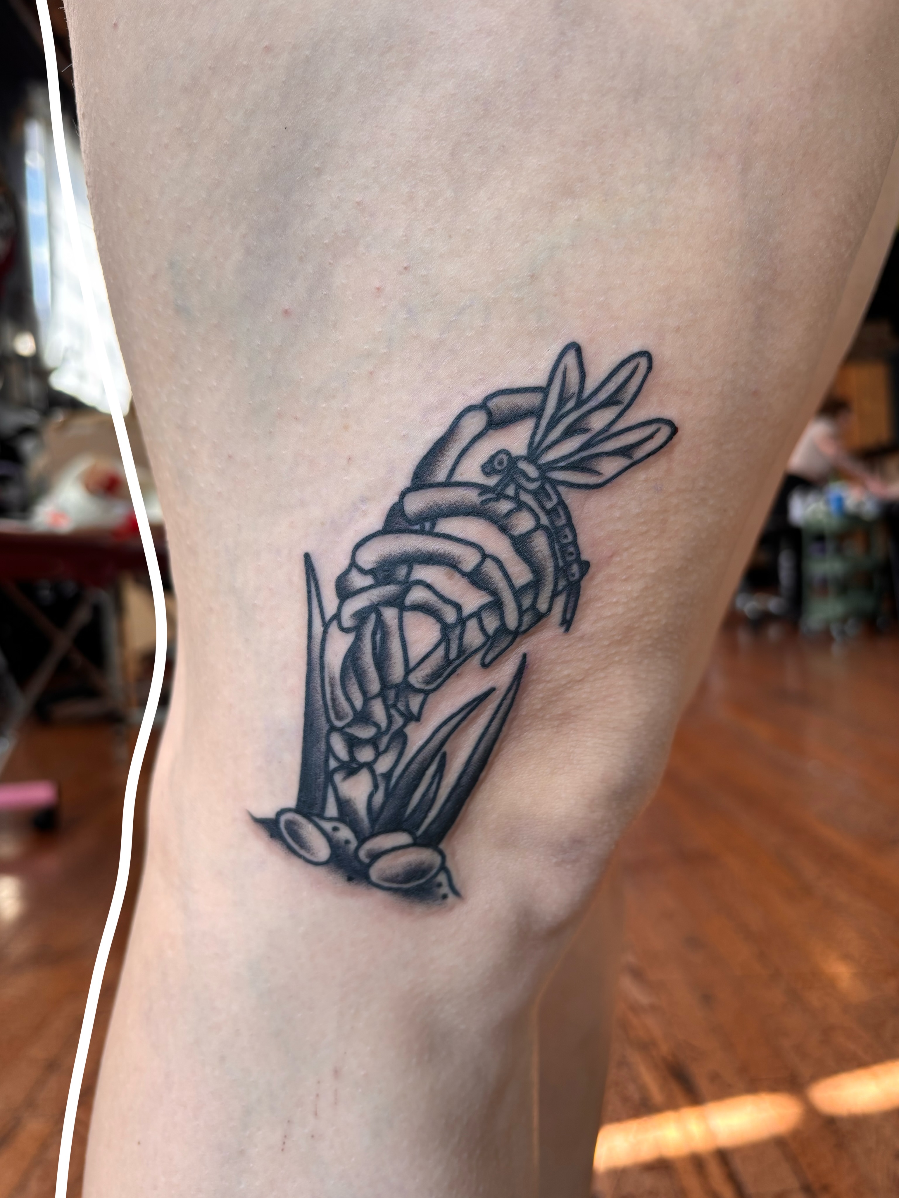 Rose and dragonfly black and grey tattoo on the thigh by Emmy Stepien