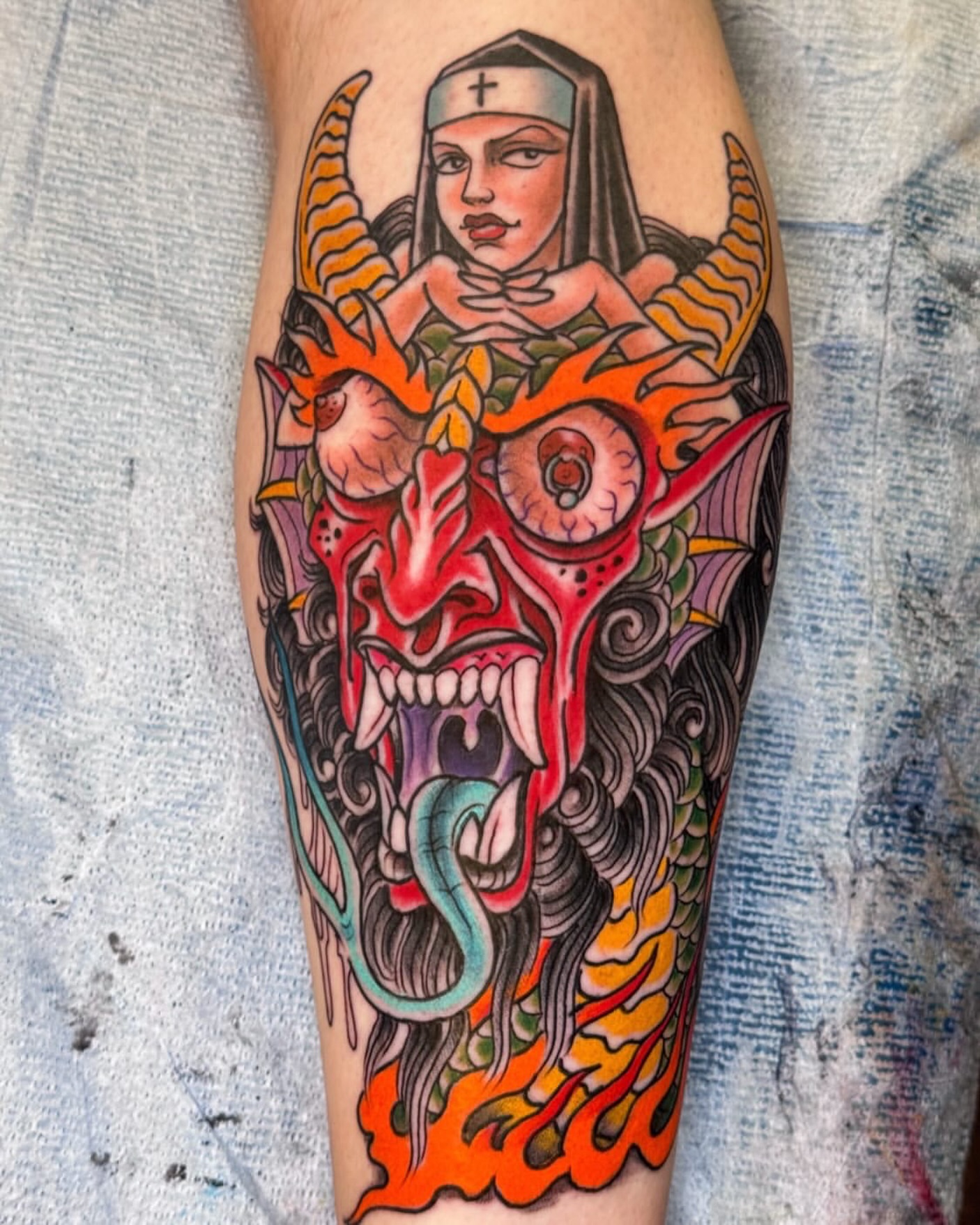 Nun and demon American traditional tattoo on the forearm by Bob Lackner