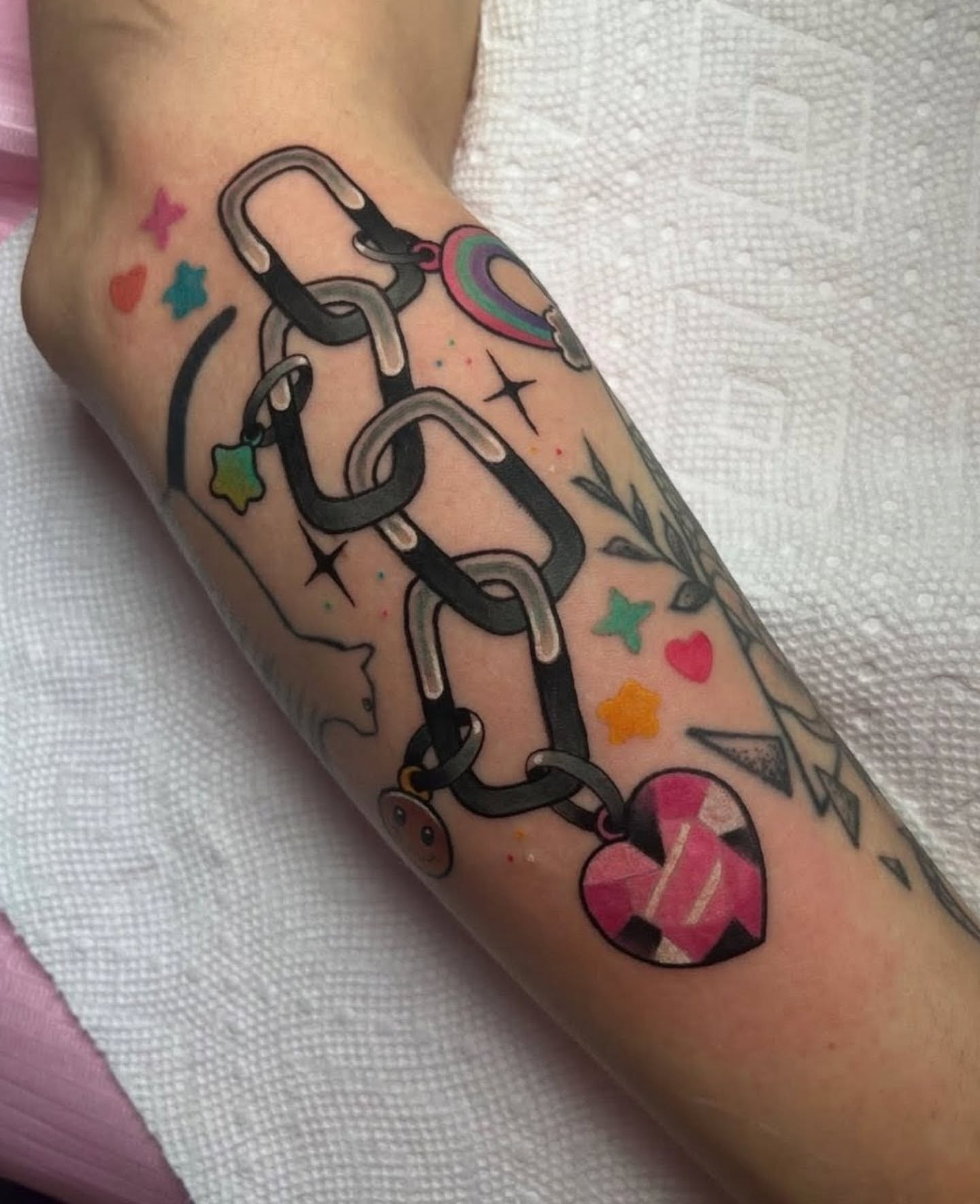 Chain and charms American traditional tattoo on the forearm by Chloe Marie