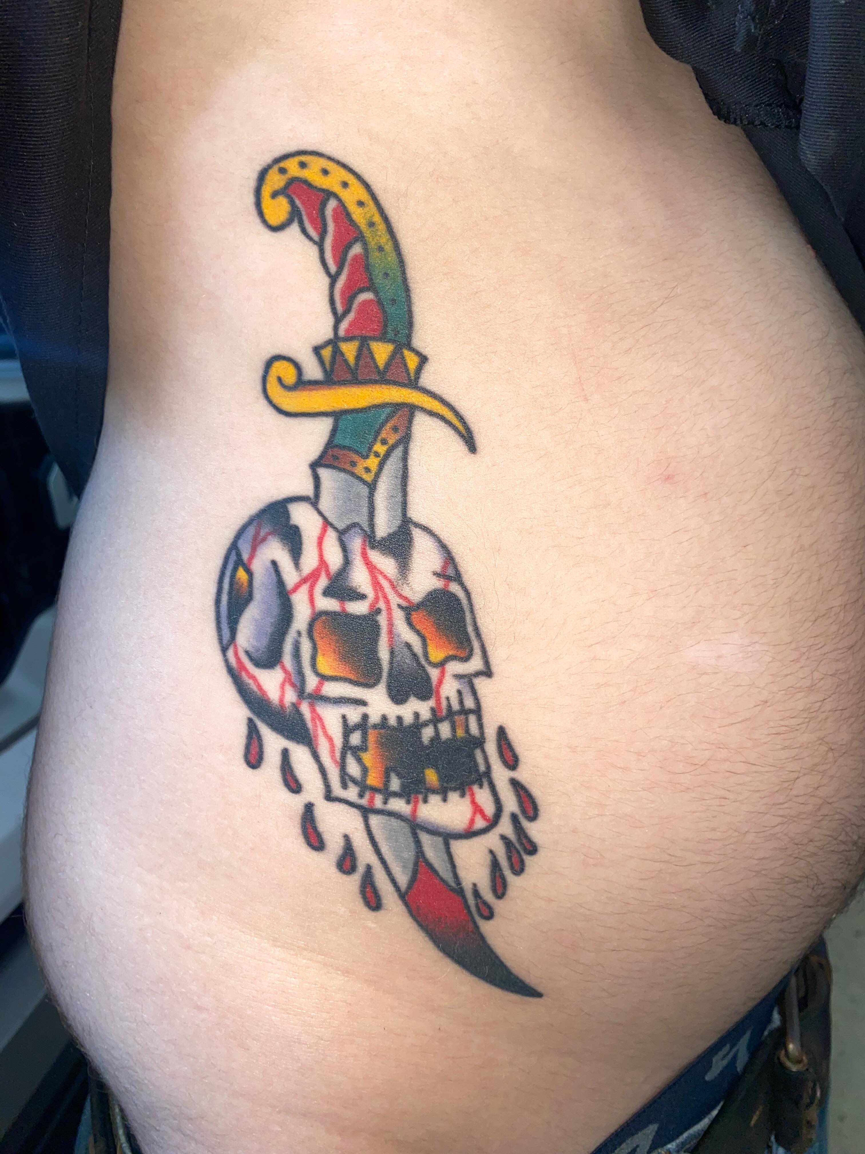 Skull with dagger American traditional tattoo on the ribs by Nosferatu