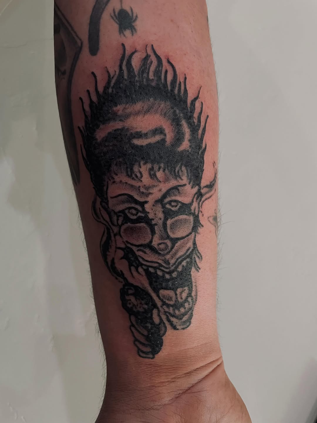 Demonic face with glasses tattoo on the forearm by Christien Xavier Alba, Salt Lake City, Utah