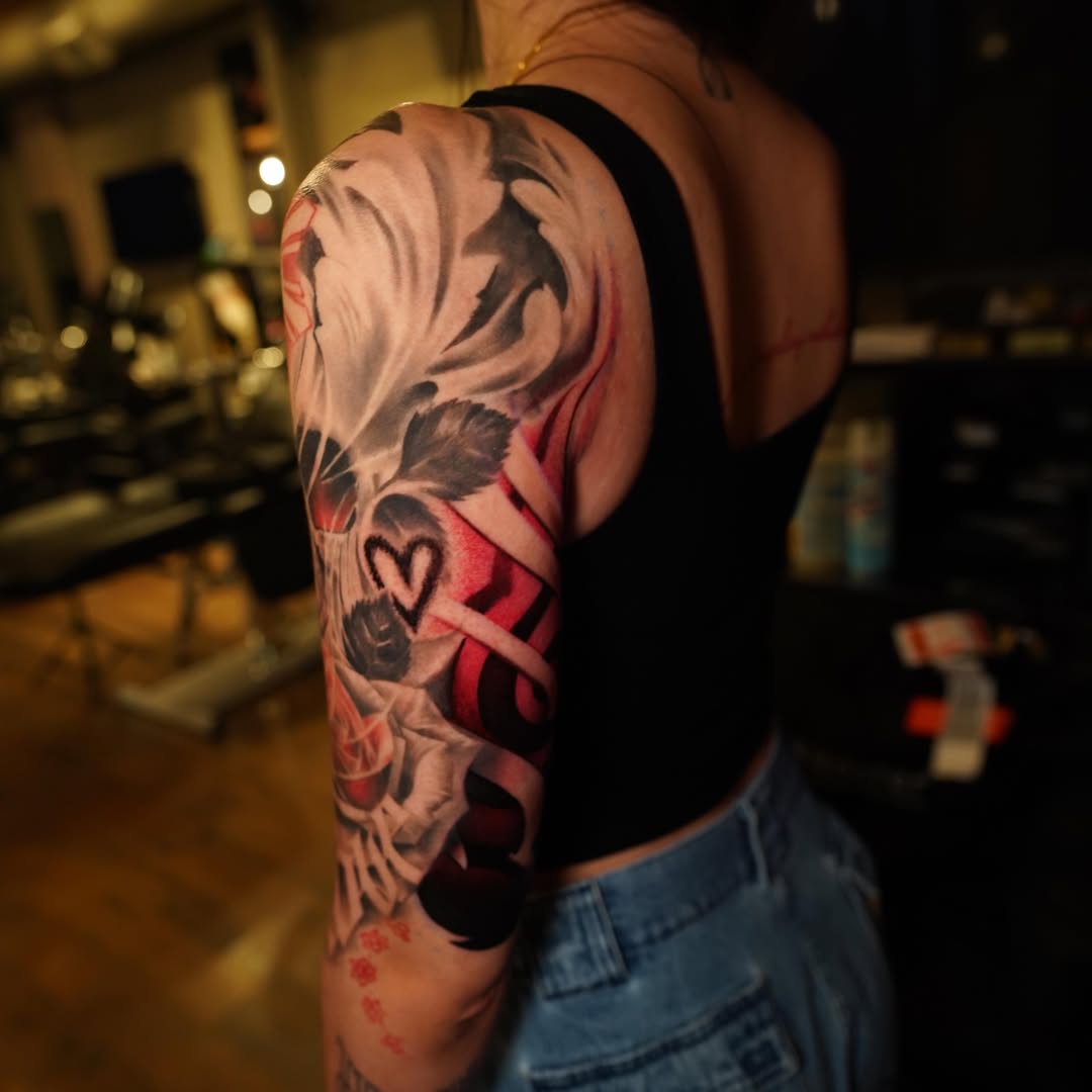 Skull and roses realism tattoo on the upper arm by Erick Satchell II