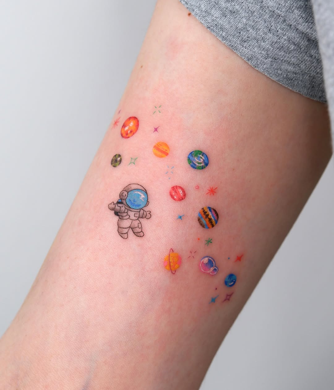 Astronaut and planets watercolor tattoo on the forearm by 타투 Seon 컬러타투