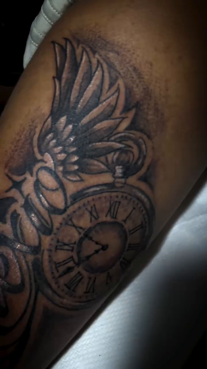 Clock with wings and crown realism tattoo on the upper arm by Jonny Vicious