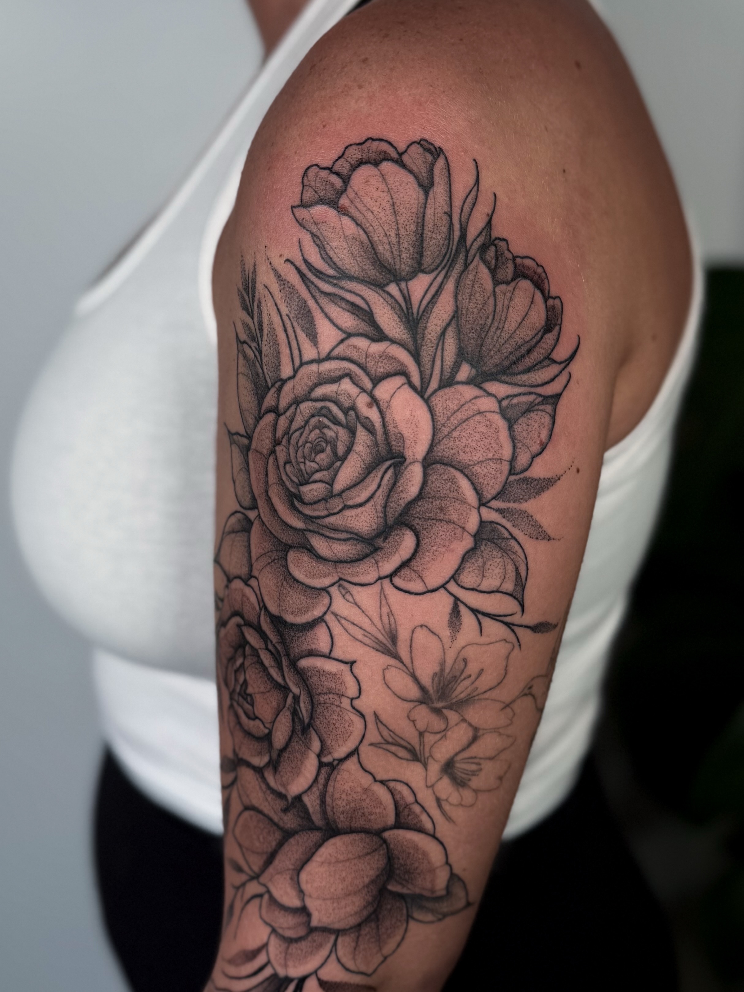 Flowers dotwork tattoo on the upper arm by Jessica Bloom