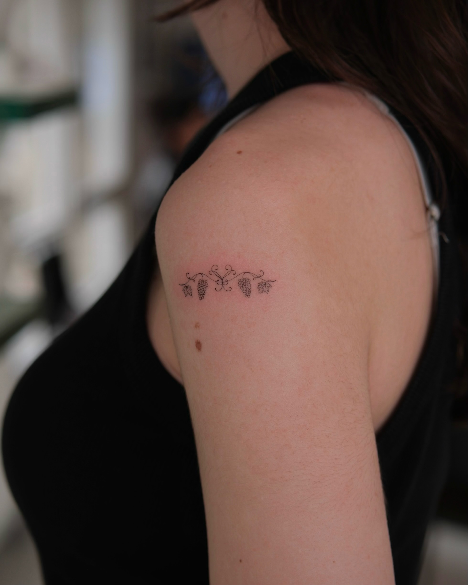 Grapes and vines fine line tattoo on the shoulder by Göksu