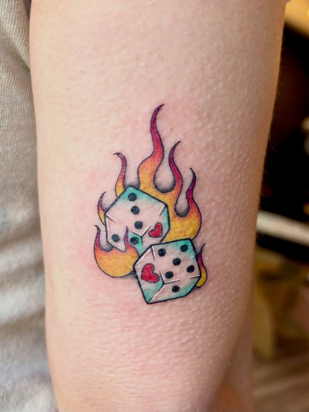 Dice on fire American traditional tattoo on the forearm by Bianca Cattapan