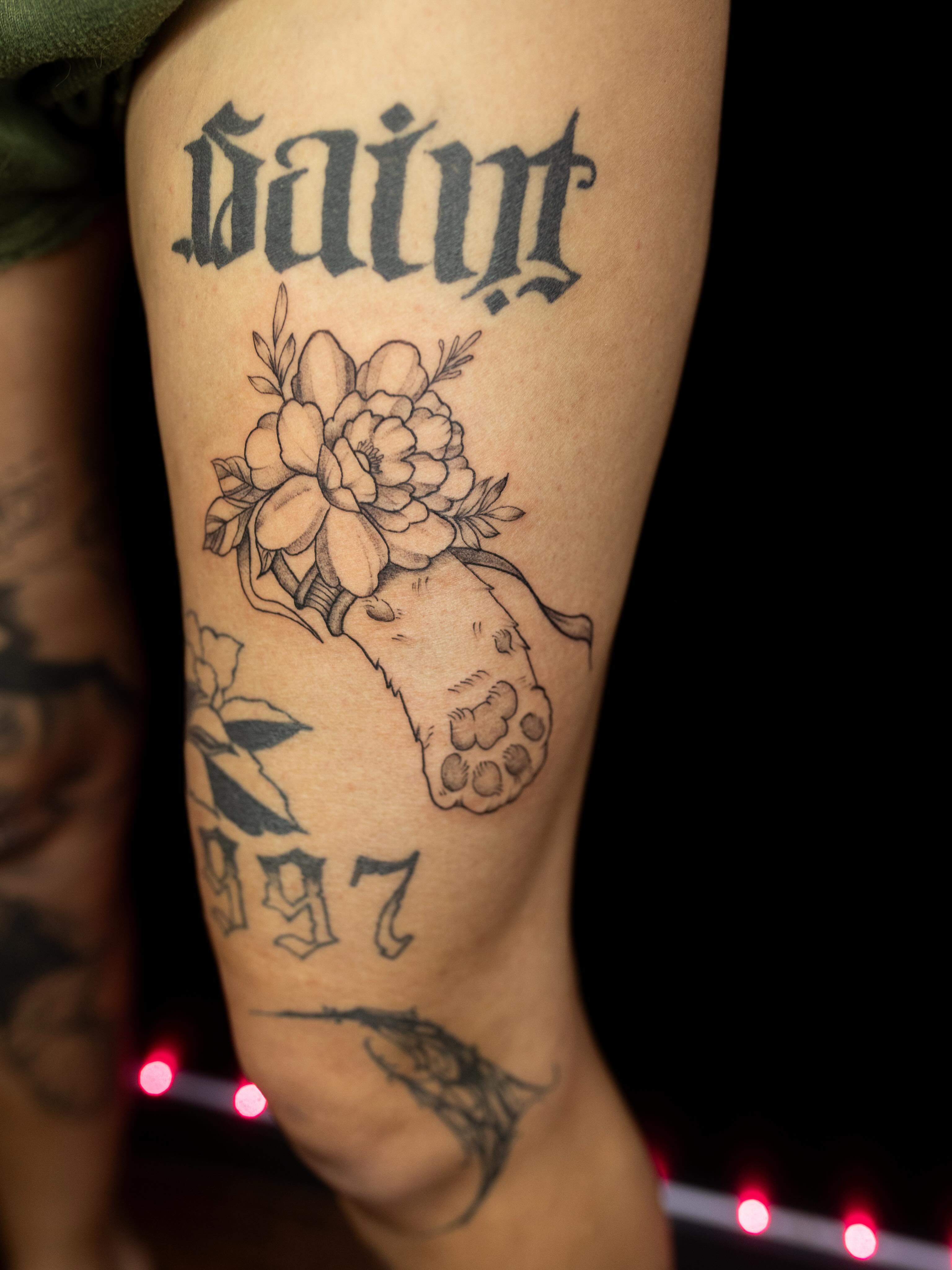Peony and paw print black and grey tattoo on the forearm by Kelsie