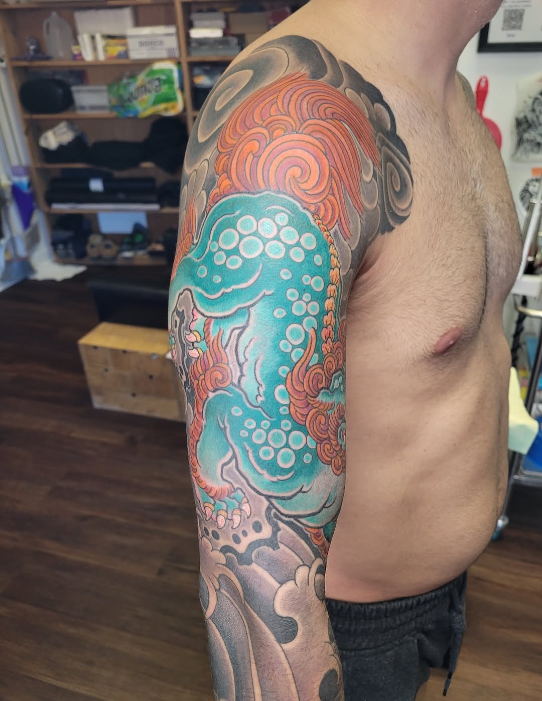 Foo dog with waves Japanese tattoo on the upper arm by Mark Harada, Hoboken, New Jersey
