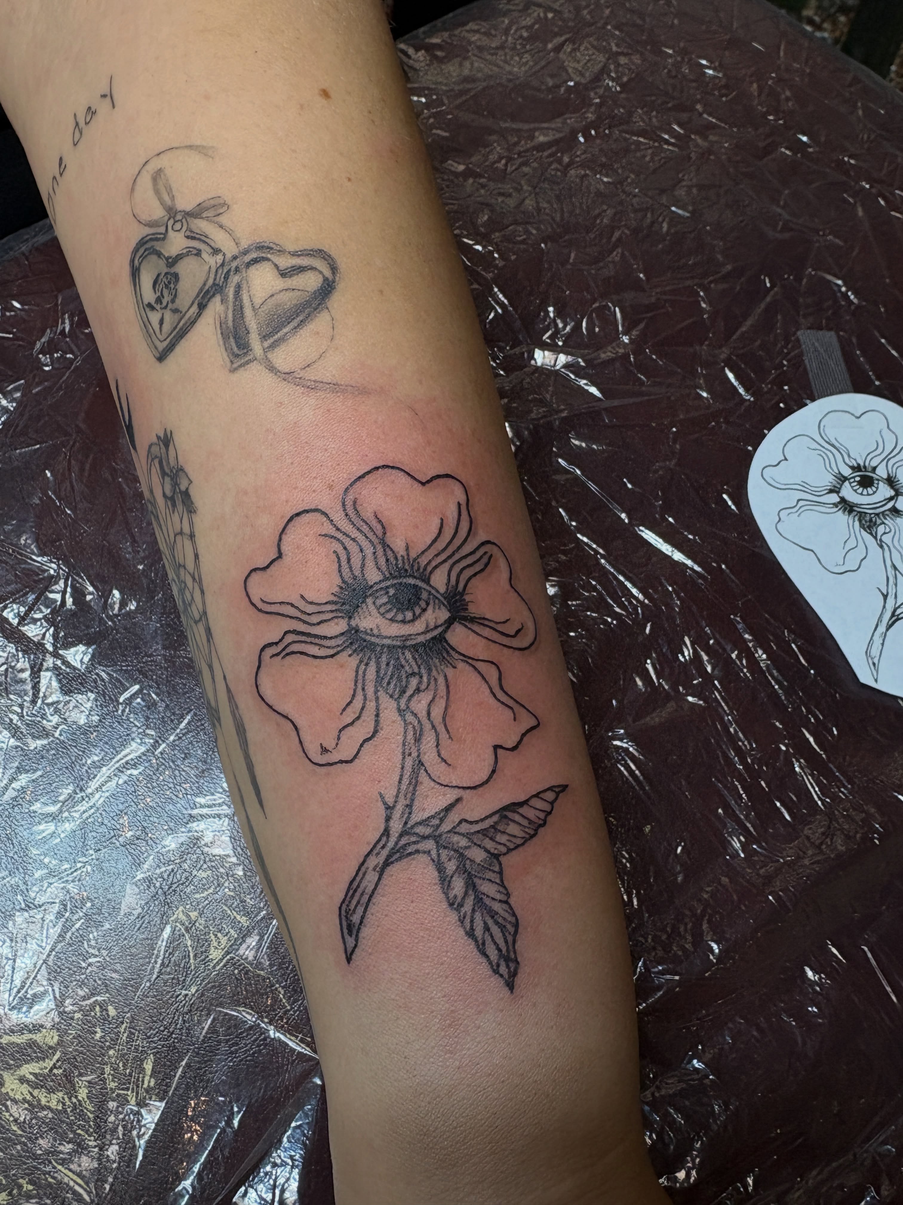 Eye within flower black and grey tattoo on the forearm by ⋆.˚ ☾ .⭒˚ alaina