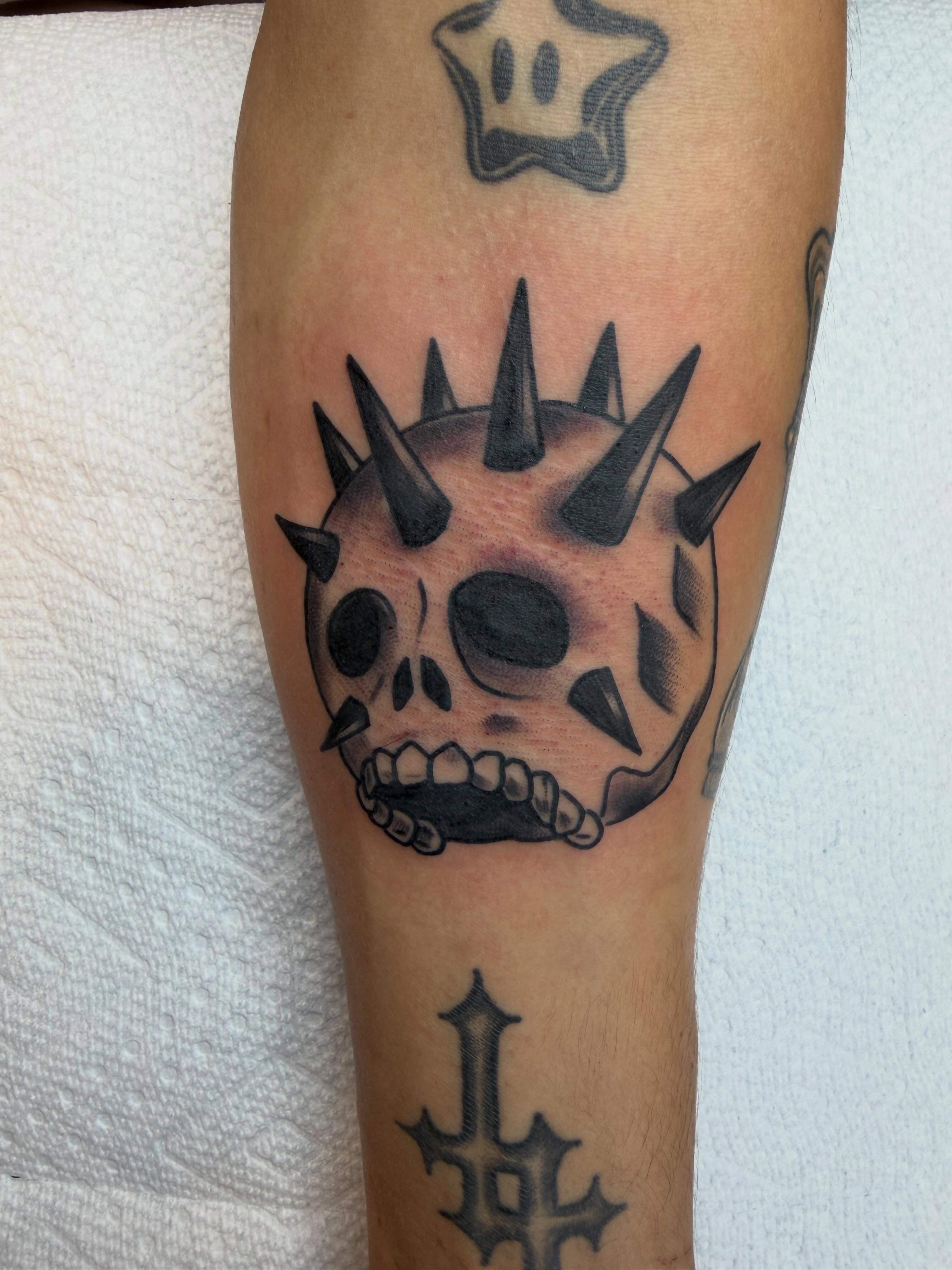 Spiked skull realism tattoo on the forearm by Evan Voelker