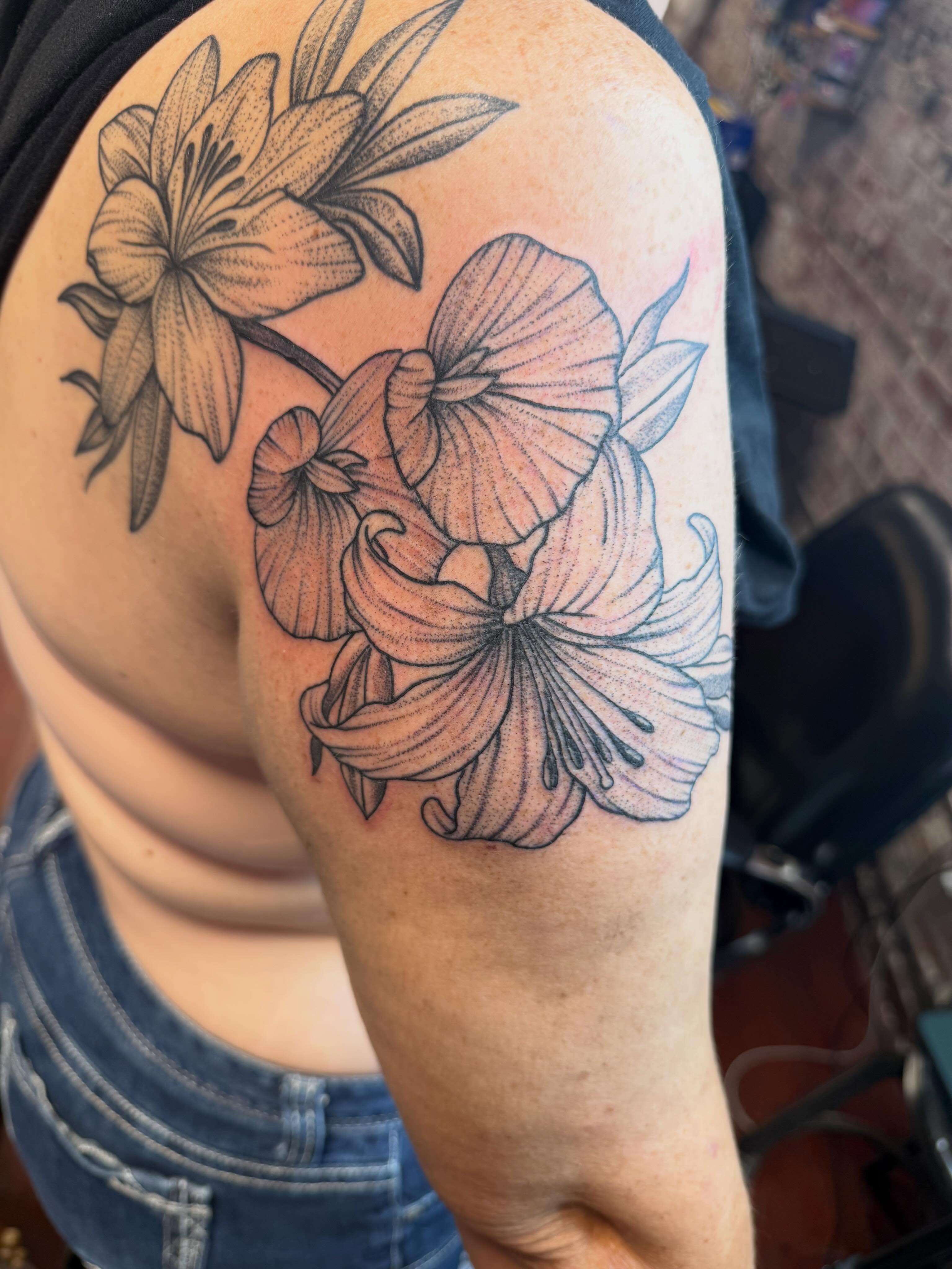 Lilies dotwork tattoo on the shoulder by Evan Voelker