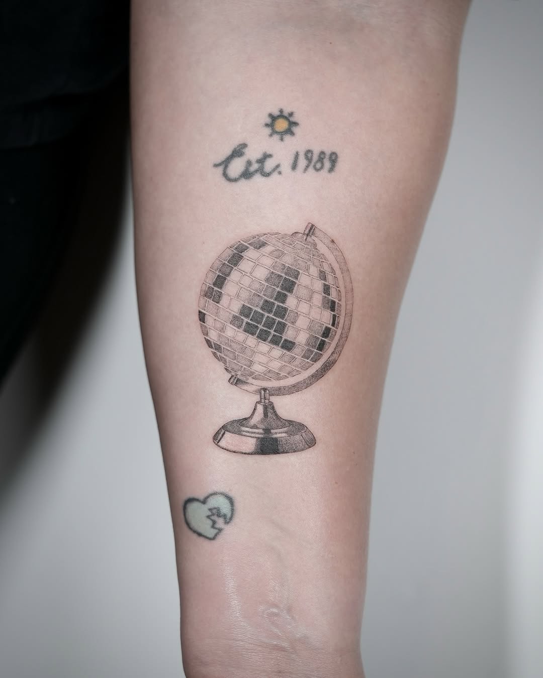 Disco ball and text minimalist tattoo on the forearm by Jennifer Fuster
